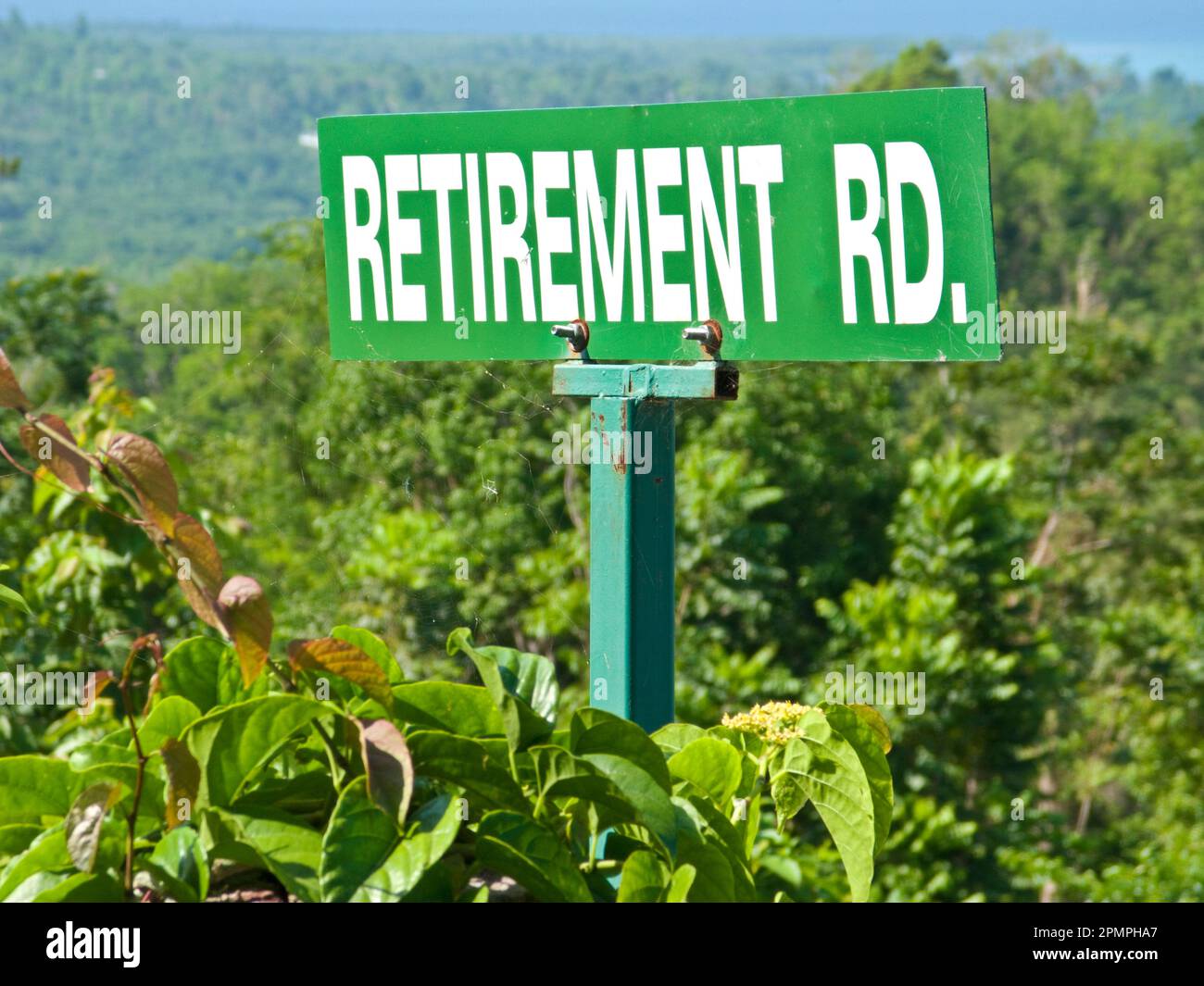 Auf dem Schild „Retirement Road“ in der üppigen Landschaft steht „Retirement Road“; Bluefields Bay, Jamaika Stockfoto