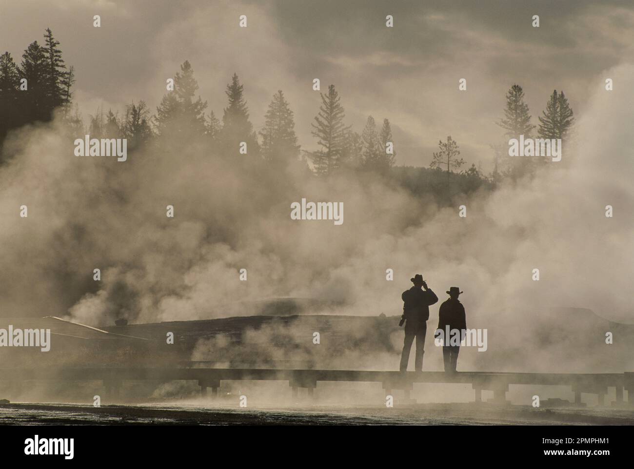 Touristen in geothermischem Dampf und Nebel in der Nähe des Upper Geyser Basin, Yellowstone National Park, USA; Wyoming, Vereinigte Staaten von Amerika Stockfoto