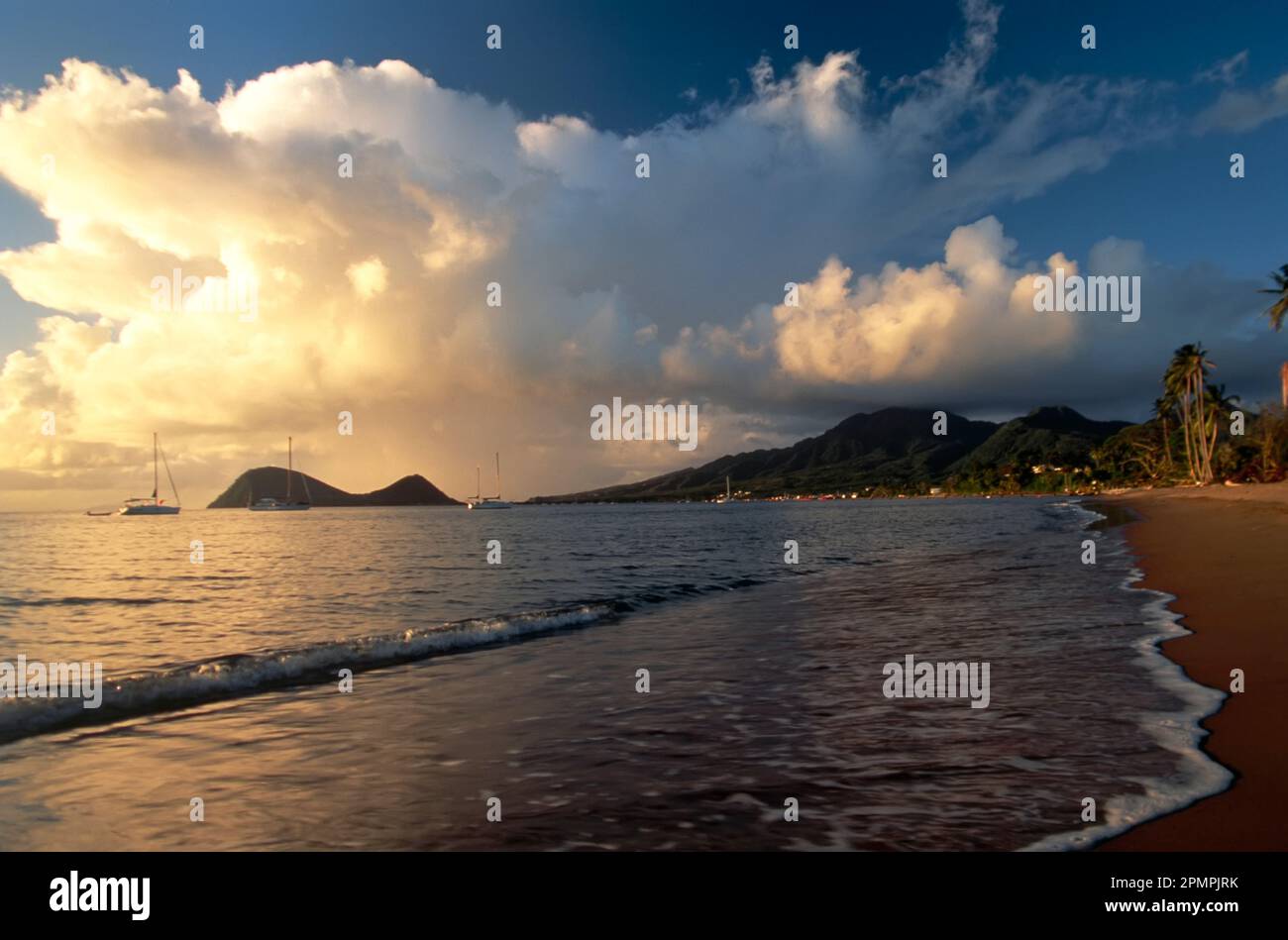 Vom Coconut Beach, einem der einzigen Sandstrände auf der Insel, kann man eine dramatische Wolkenbildung über dem hügeligen Portsmouth sehen, die sich erstreckt... Stockfoto