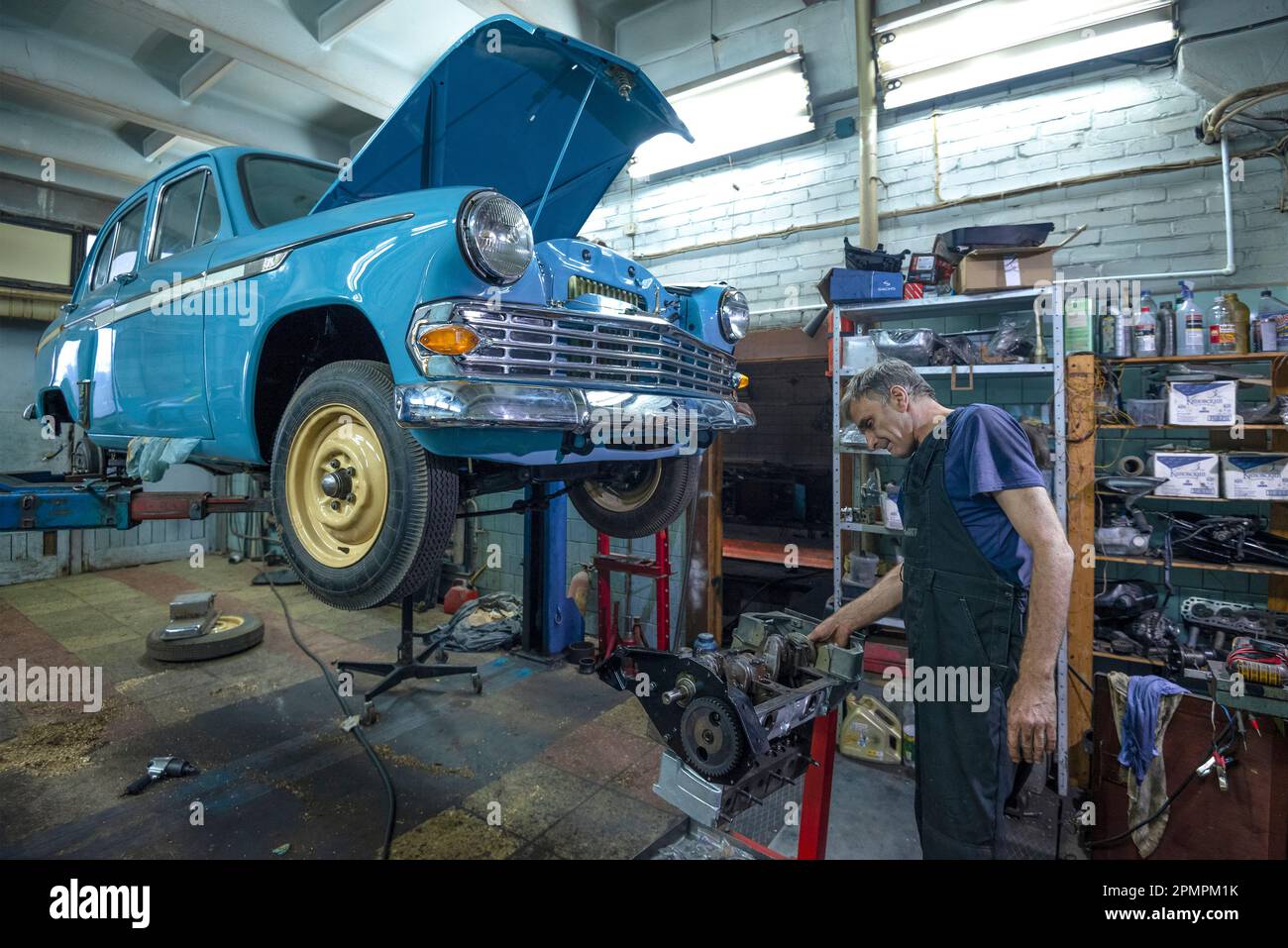 ST. PETERSBURG, RUSSLAND - 03. AUGUST 2020: Automechaniker in der Garage reparieren den Motor des sowjetischen Retro-Autos Moskvich-403 Stockfoto