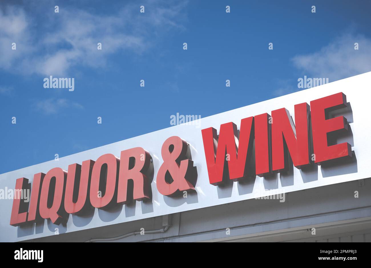 Ein Schild für einen Spirituosen- und Weinladen vor dem leuchtenden blauen Himmel Stockfoto