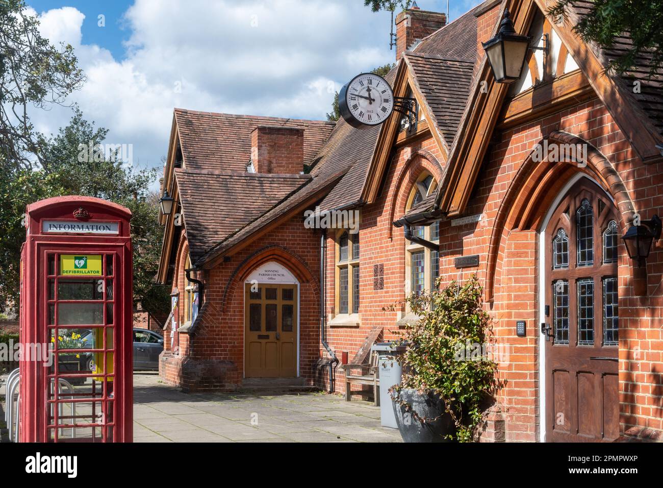 Pearson Hall, in der auch das gemeinderatsbüro und der Sonning Club untergebracht sind, im Dorf Sonning-on-Thames, Berkshire, England, Großbritannien, mit roter Telefonzelle Stockfoto
