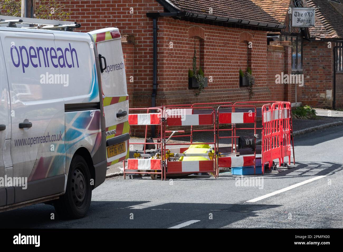 Ein Openreach-Ingenieur, der in einem englischen Dorf in Berkshire, England, ein Loch in der Straße baute Stockfoto