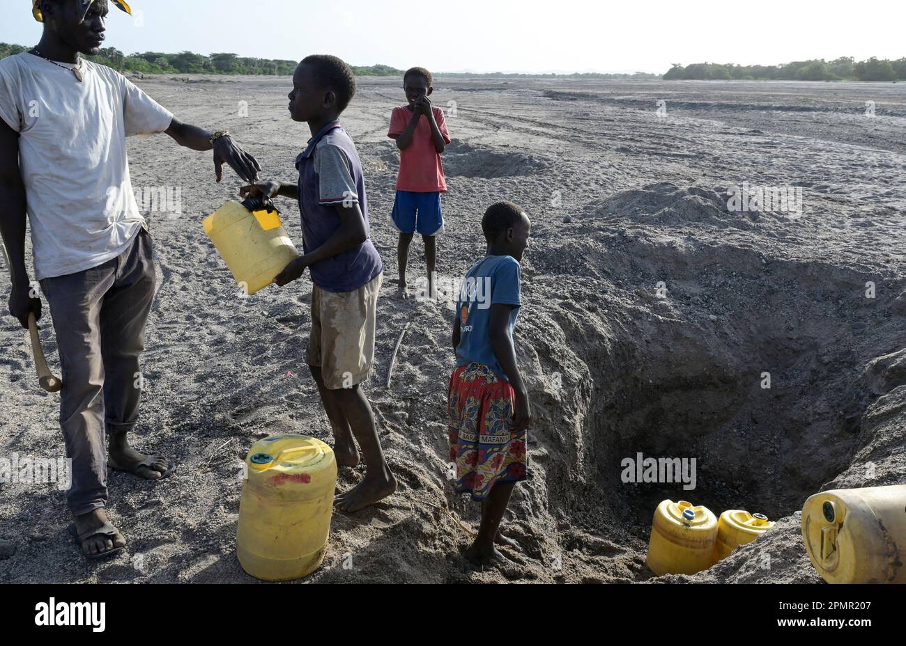 KENIA, Turkana, Dürre, trockenes Flussbett, Menschen holen Wasser aus ausgegrabenen Löchern / KENIA, Turkana, Dürre, trockenes Flußbett, Wasserloch, Menschen schöpfen Wasser aus gegrabenen Löchern im Fluß Stockfoto