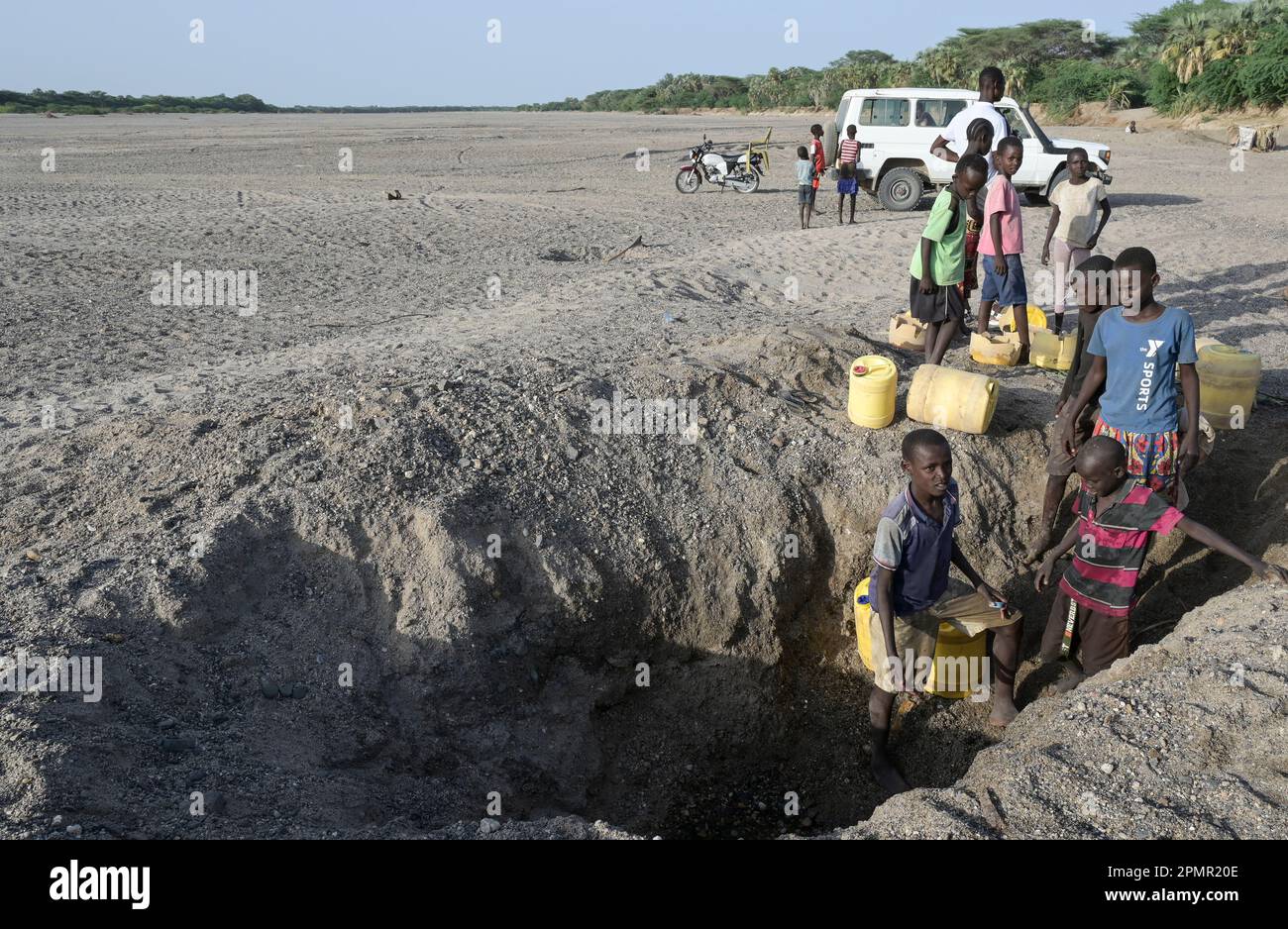 KENIA, Turkana, Dürre, trockenes Flussbett, Menschen holen Wasser aus ausgegrabenen Löchern / KENIA, Turkana, Dürre, trockenes Flußbett, Wasserloch, Menschen schöpfen Wasser aus gegrabenen Löchern im Fluß Stockfoto