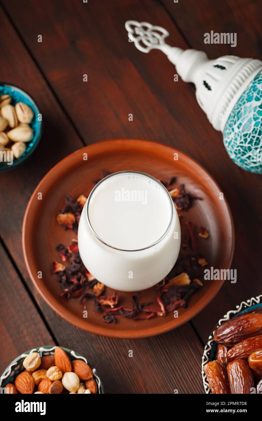 Ramadan Kareem und iftar muslimisches Essen. Entsteinte Datteln, Nüsse und Milch auf Holzbrettern. Traditionelles iftar-Essen Stockfoto