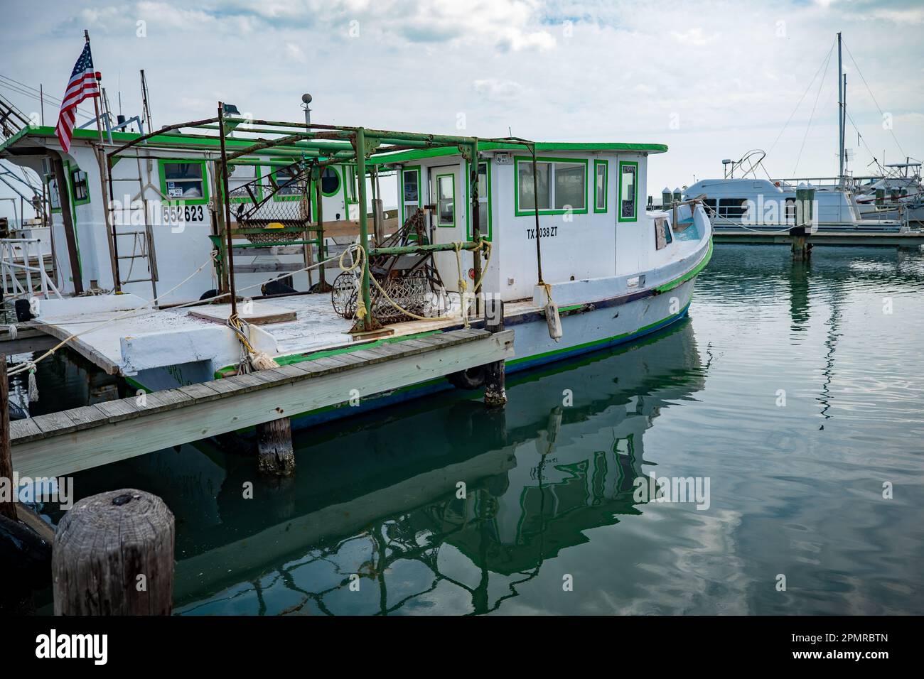 ROCKPORT, TX - 14. FEBRUAR 2023: Ein kommerzielles Fischerboot, das an einem überwiegend bewölkten Tag an einem Dock im Yachthafen in Rockport, Texas, vor Anker liegt. Stockfoto