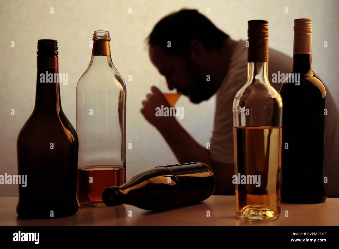 Silhouette der Anonymen Alkoholiker person Trinken hinter Flaschen Alkohol Stockfoto