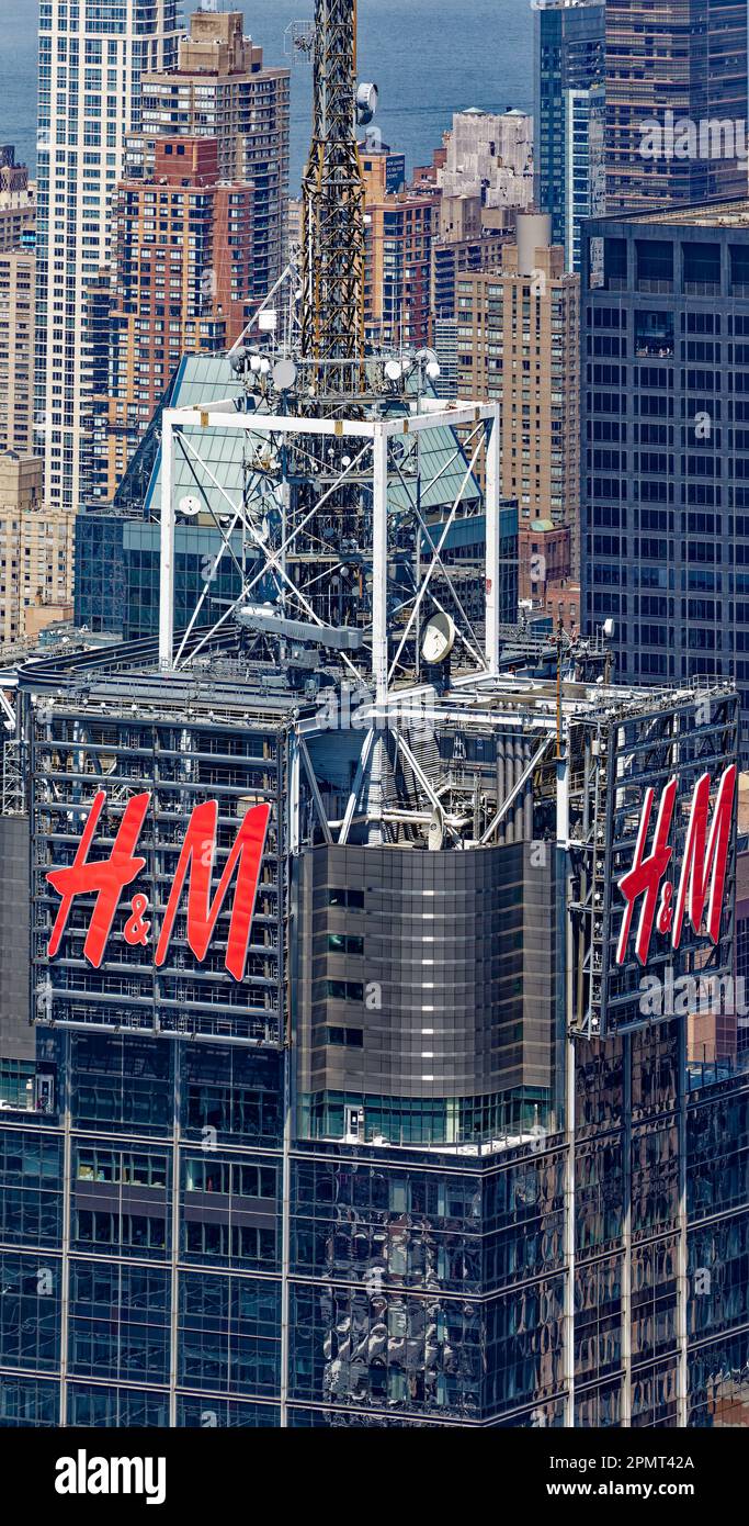 Blick von oben: 151 West 42. Street, auch bekannt als 4 Times Square und ehemals Conde Nast Building, trägt das H&M-Logo auf dem Mauerwerk und dem Glasturm. Stockfoto