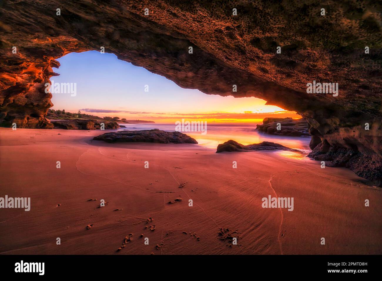 Malerische Meereshöhle am Caves Beach an der Pazifikküste Australiens bei Sonnenaufgang - extreme Meereslandschaft. Stockfoto