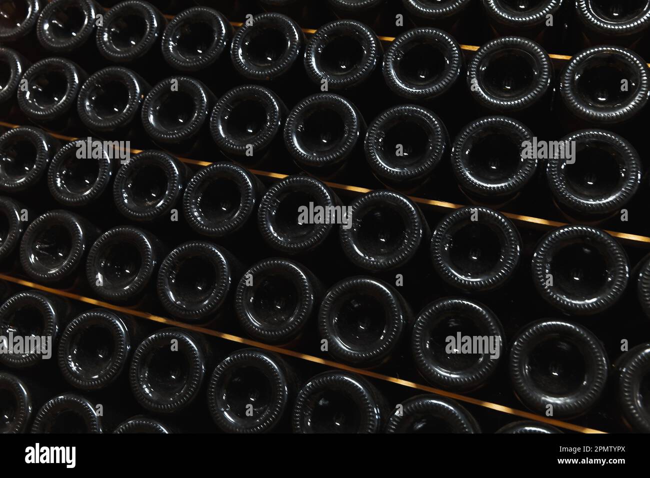 Gestapelte, staubige Flaschen Wein lagen in einem Weinkeller Stockfoto