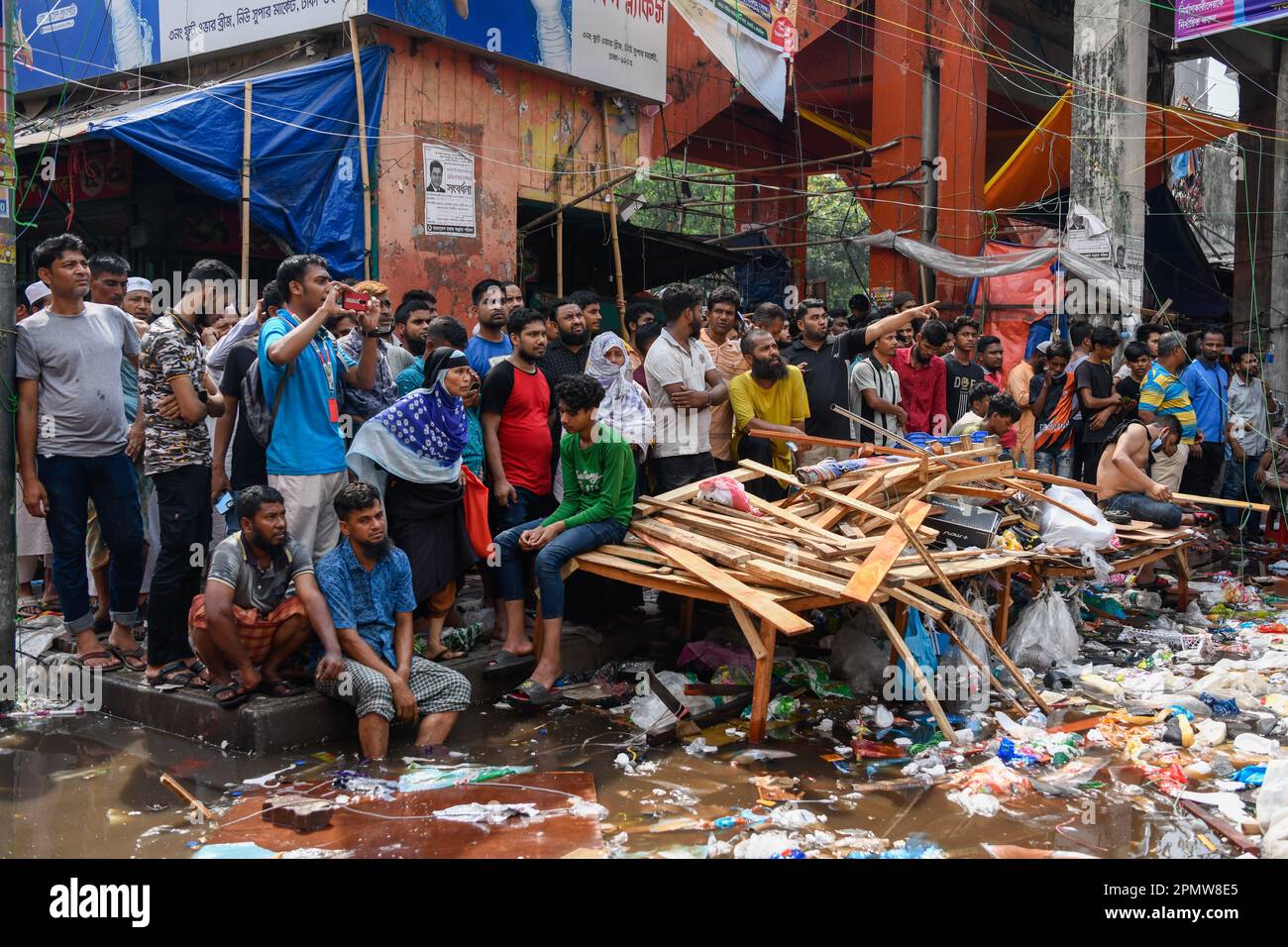 Die Leute versammeln sich auf Dhakas neuem Supermarkt nach einem furchtbaren Feuerwehrauto auf dem Bekleidungsmarkt in Dhaka. Ein Großbrand hat Tausende von Geschäften auf einem beliebten Bekleidungsmarkt in der Hauptstadt von Bangladesch, Dhaka, zerstört. Ladenbesitzer wurden durch den Verlust Wochen vor Eid, dem muslimischen Festival, das das Ende des Ramadan markiert, verwüstet. Hunderte von Feuerwehrleuten und Armeepersonal kämpften gegen das Inferno, als es den Bekleidungsmarkt durchwühlte und es in einen Haufen Asche verwandelte. Mehrere Menschen wurden verletzt, aber bisher wurden keine Todesfälle gemeldet. Die Behörden versuchten immer noch, die Ursache für den Brand herauszufinden Stockfoto
