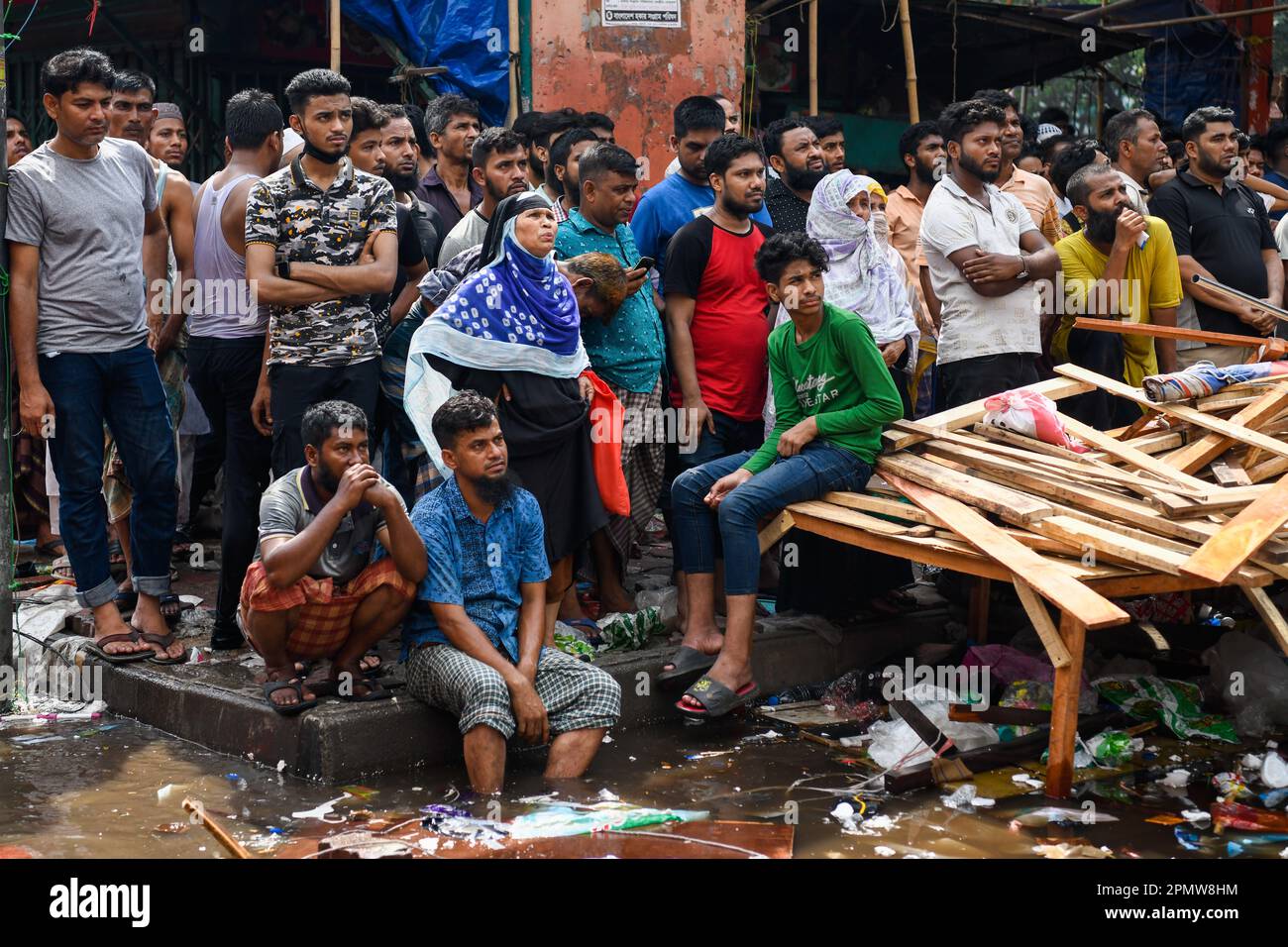 Die Leute versammeln sich auf Dhakas neuem Supermarkt nach einem furchtbaren Feuerwehrauto auf dem Bekleidungsmarkt in Dhaka. Ein Großbrand hat Tausende von Geschäften auf einem beliebten Bekleidungsmarkt in der Hauptstadt von Bangladesch, Dhaka, zerstört. Ladenbesitzer wurden durch den Verlust Wochen vor Eid, dem muslimischen Festival, das das Ende des Ramadan markiert, verwüstet. Hunderte von Feuerwehrleuten und Armeepersonal kämpften gegen das Inferno, als es den Bekleidungsmarkt durchwühlte und es in einen Haufen Asche verwandelte. Mehrere Menschen wurden verletzt, aber bisher wurden keine Todesfälle gemeldet. Die Behörden versuchten immer noch, die Ursache für den Brand herauszufinden Stockfoto