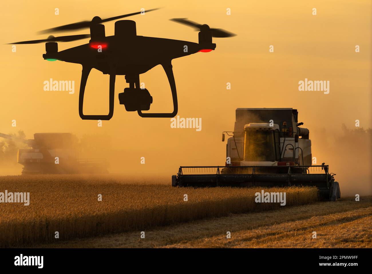 Silhouetten von Mähdrescher und Drohne. Hochwertiges Foto Stockfoto