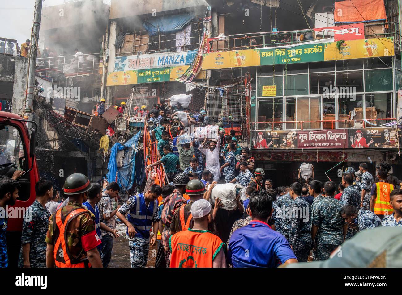 Dhaka, Bangladesch. 15. April 2023. Unternehmenseigentümer bringen ihre Waren vom Brandort im neuen Supermarkt in Dhaka. In Dhakas neuem Supermarkt, einem der größten Bekleidungsmärkte des Landes, vor Eid-ul-Fitr, hat ein massives Feuer die Geschäfte ausgelöscht. Einsatzkräfte der Armee, der Luftwaffe, des Schnelleinsatzbataillons, der Polizei von Bangladesch und des Grenzschutzes Bangladesch haben sich mit 28 Feuerwehr- und Zivilschutzeinheiten zusammengetan, um am Samstag die Flammen zu zähmen. Kredit: SOPA Images Limited/Alamy Live News Stockfoto