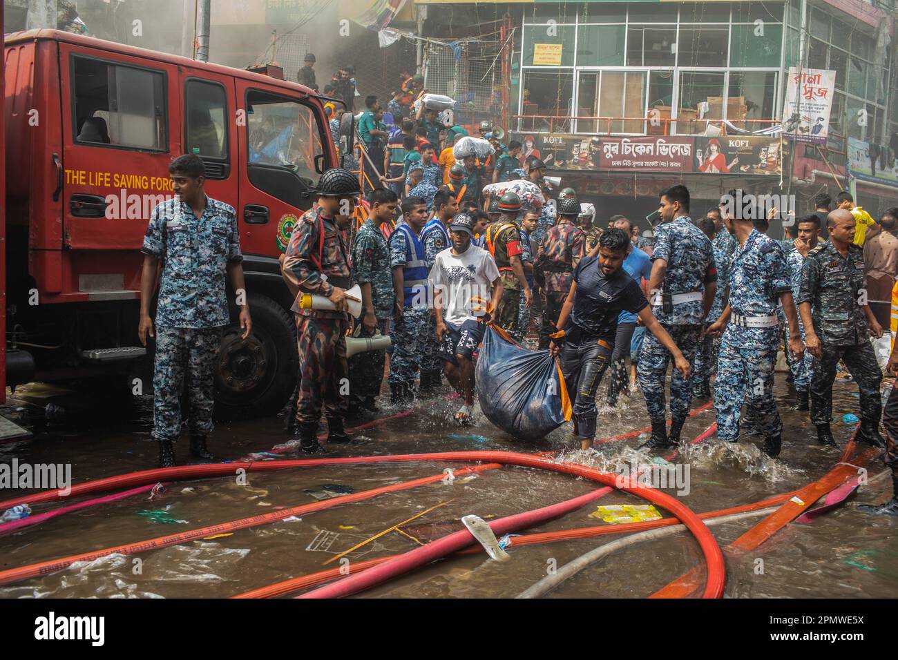Dhaka, Bangladesch. 15. April 2023. Unternehmenseigentümer bringen ihre Waren vom Brandort im neuen Supermarkt in Dhaka. In Dhakas neuem Supermarkt, einem der größten Bekleidungsmärkte des Landes, vor Eid-ul-Fitr, hat ein massives Feuer die Geschäfte ausgelöscht. Einsatzkräfte der Armee, der Luftwaffe, des Schnelleinsatzbataillons, der Polizei von Bangladesch und des Grenzschutzes Bangladesch haben sich mit 28 Feuerwehr- und Zivilschutzeinheiten zusammengetan, um am Samstag die Flammen zu zähmen. Kredit: SOPA Images Limited/Alamy Live News Stockfoto