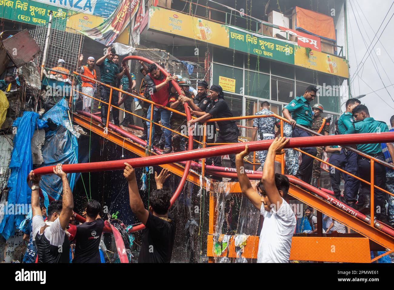 Dhaka, Bangladesch. 15. April 2023. Die drei uniformierten Militärdienste des Landes, Armee, Marine, Luftwaffe und das Schnelleinsatzbataillon helfen, ein Feuer im New Supermarket in Dhaka zu löschen. In Dhakas neuem Supermarkt, einem der größten Bekleidungsmärkte des Landes, vor Eid-ul-Fitr, hat ein massives Feuer die Geschäfte ausgelöscht. Einsatzkräfte der Armee, der Luftwaffe, des Schnelleinsatzbataillons, der Polizei von Bangladesch und des Grenzschutzes Bangladesch haben sich mit 28 Feuerwehr- und Zivilschutzeinheiten zusammengetan, um am Samstag die Flammen zu zähmen. Kredit: SOPA Images Limited/Alamy Live News Stockfoto