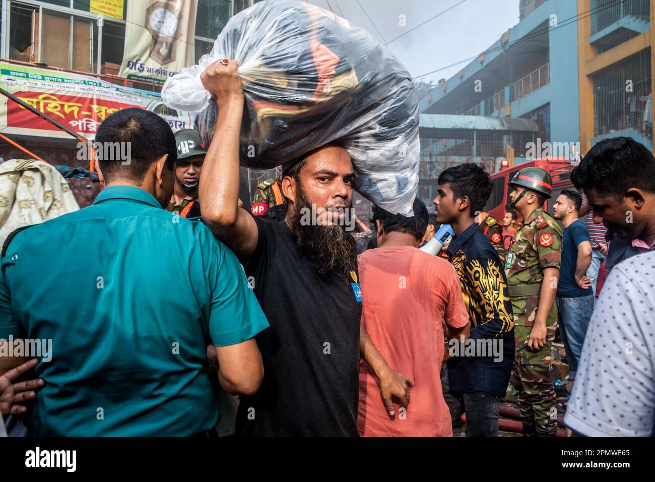 Dhaka, Bangladesch. 15. April 2023. Ein Geschäftseigentümer bringt seine Waren vom Brandort im neuen Supermarkt in Dhaka. In Dhakas neuem Supermarkt, einem der größten Bekleidungsmärkte des Landes, vor Eid-ul-Fitr, hat ein massives Feuer die Geschäfte ausgelöscht. Einsatzkräfte der Armee, der Luftwaffe, des Schnelleinsatzbataillons, der Polizei von Bangladesch und des Grenzschutzes Bangladesch haben sich mit 28 Feuerwehr- und Zivilschutzeinheiten zusammengetan, um am Samstag die Flammen zu zähmen. Kredit: SOPA Images Limited/Alamy Live News Stockfoto