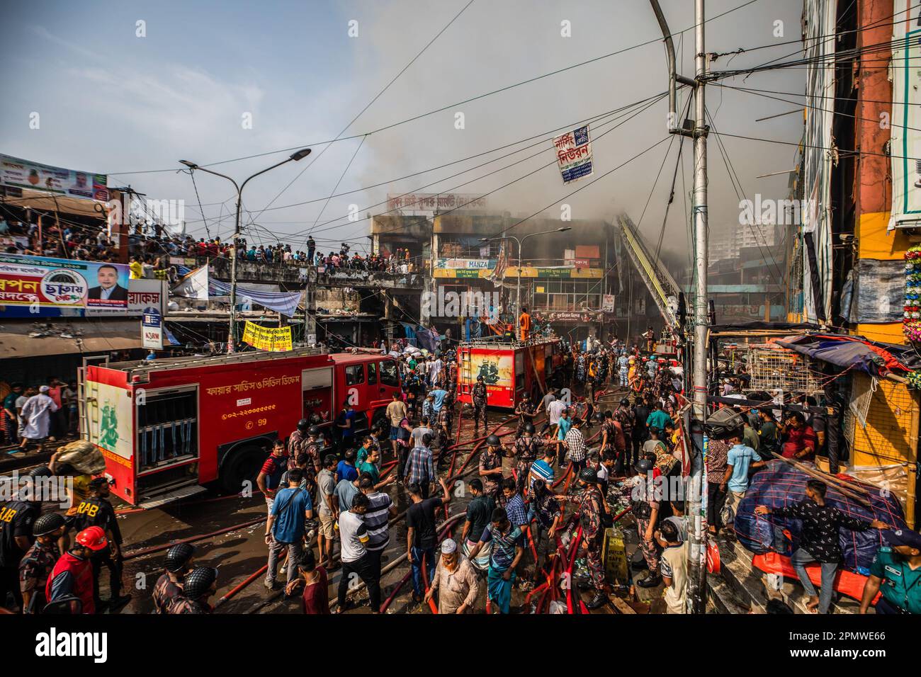 Dhaka, Bangladesch. 15. April 2023. Die drei uniformierten Militärdienste des Landes, Armee, Marine, Luftwaffe und das Schnelleinsatzbataillon helfen, ein Feuer im New Supermarket in Dhaka zu löschen. In Dhakas neuem Supermarkt, einem der größten Bekleidungsmärkte des Landes, vor Eid-ul-Fitr, hat ein massives Feuer die Geschäfte ausgelöscht. Einsatzkräfte der Armee, der Luftwaffe, des Schnelleinsatzbataillons, der Polizei von Bangladesch und des Grenzschutzes Bangladesch haben sich mit 28 Feuerwehr- und Zivilschutzeinheiten zusammengetan, um am Samstag die Flammen zu zähmen. Kredit: SOPA Images Limited/Alamy Live News Stockfoto