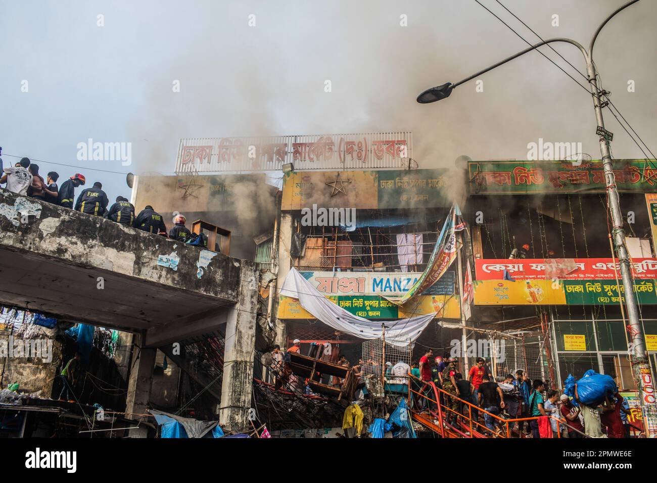 Dhaka, Bangladesch. 15. April 2023. Rauch füllt die Luft bei einem Brand im neuen Supermarkt in Dhaka. In Dhakas neuem Supermarkt, einem der größten Bekleidungsmärkte des Landes, vor Eid-ul-Fitr, hat ein massives Feuer die Geschäfte ausgelöscht. Einsatzkräfte der Armee, der Luftwaffe, des Schnelleinsatzbataillons, der Polizei von Bangladesch und des Grenzschutzes Bangladesch haben sich mit 28 Feuerwehr- und Zivilschutzeinheiten zusammengetan, um am Samstag die Flammen zu zähmen. Kredit: SOPA Images Limited/Alamy Live News Stockfoto