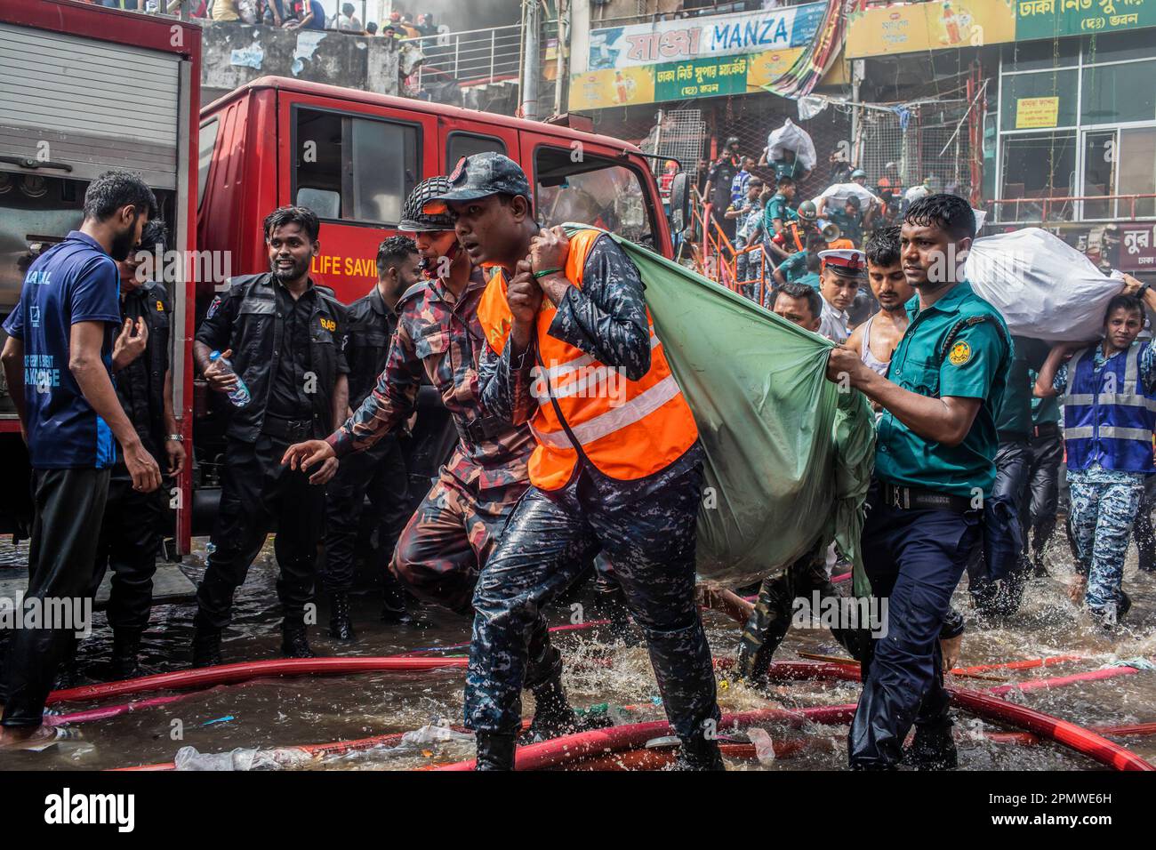 Dhaka, Bangladesch. 15. April 2023. Unternehmenseigentümer bringen ihre Waren vom Brandort im neuen Supermarkt in Dhaka. In Dhakas neuem Supermarkt, einem der größten Bekleidungsmärkte des Landes, vor Eid-ul-Fitr, hat ein massives Feuer die Geschäfte ausgelöscht. Einsatzkräfte der Armee, der Luftwaffe, des Schnelleinsatzbataillons, der Polizei von Bangladesch und des Grenzschutzes Bangladesch haben sich mit 28 Feuerwehr- und Zivilschutzeinheiten zusammengetan, um am Samstag die Flammen zu zähmen. Kredit: SOPA Images Limited/Alamy Live News Stockfoto