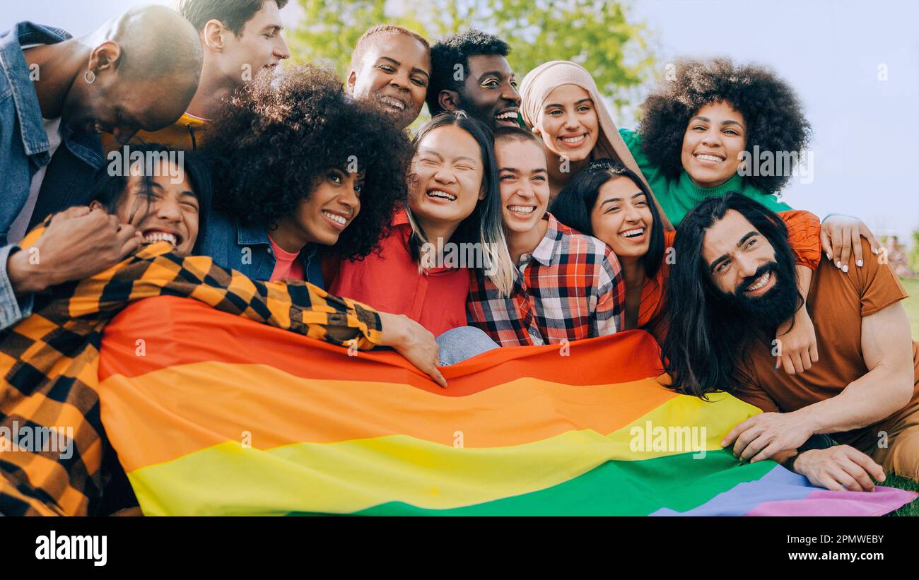 Fröhliche Menschen mit lgbt-Regenbogenflagge im Freien - Diversity Concept - Weiche Fokussierung auf das Gesicht junger asiatischer Frauen Stockfoto