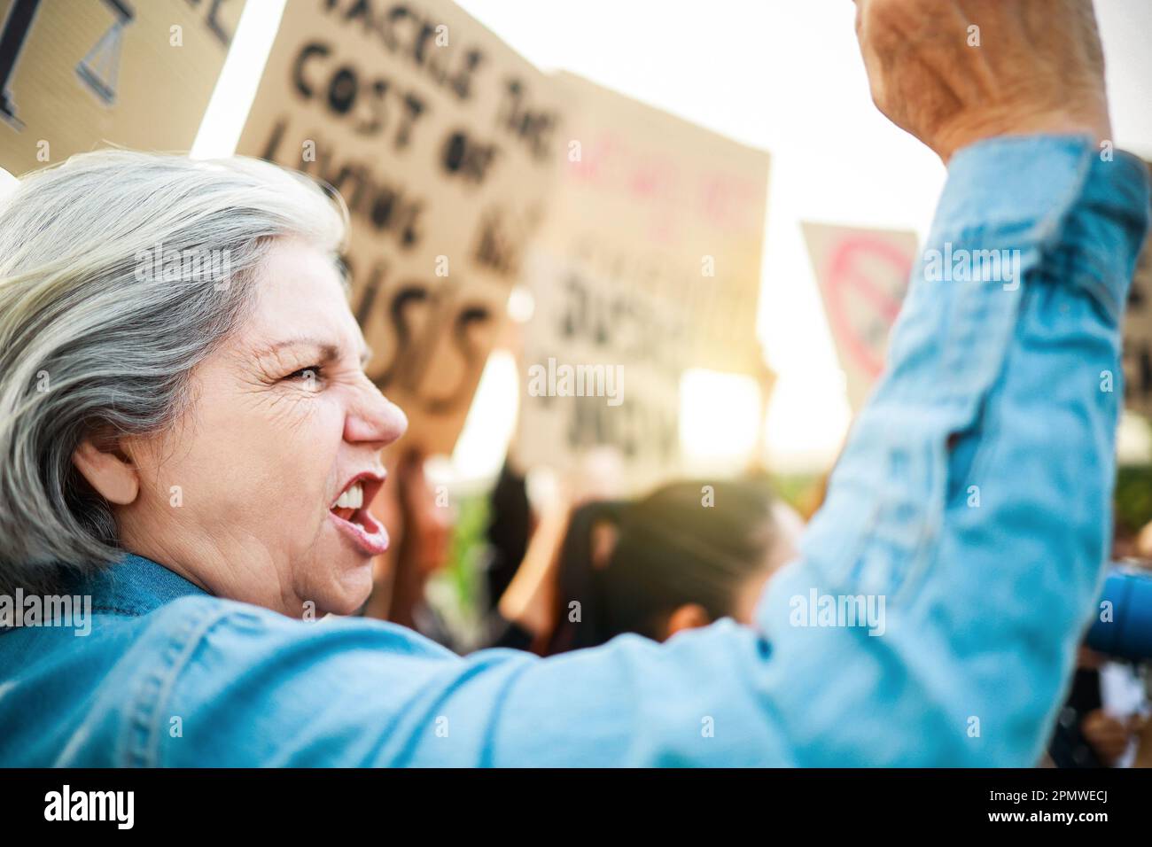 Die Menschen protestieren gegen die Demonstration der Finanzkrise auf den Straßen - ältere Frauen kämpfen in der Menge für die Weltwirtschaft Stockfoto