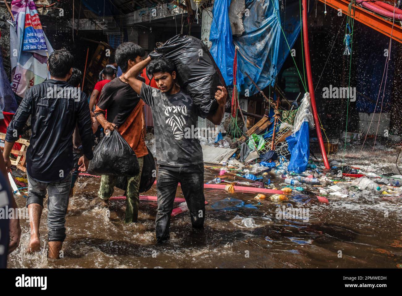 Dhaka, Bangladesch. 15. April 2023. Unternehmenseigentümer bringen ihre Waren vom Brandort im neuen Supermarkt in Dhaka. In Dhakas neuem Supermarkt, einem der größten Bekleidungsmärkte des Landes, vor Eid-ul-Fitr, hat ein massives Feuer die Geschäfte ausgelöscht. Einsatzkräfte der Armee, der Luftwaffe, des Schnelleinsatzbataillons, der Polizei von Bangladesch und des Grenzschutzes Bangladesch haben sich mit 28 Feuerwehr- und Zivilschutzeinheiten zusammengetan, um am Samstag die Flammen zu zähmen. (Foto: Sazzad Hossain/SOPA Images/Sipa USA) Guthaben: SIPA USA/Alamy Live News Stockfoto