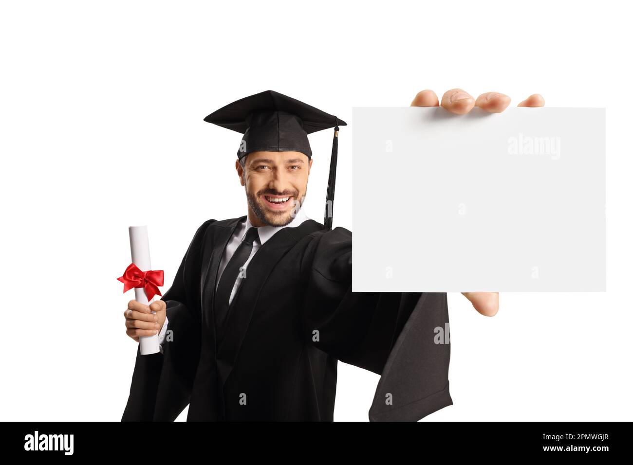 Lächelnder männlicher Student in einem Abschlusskleid mit einem Diplom und einer leeren Karte isoliert auf weißem Hintergrund Stockfoto