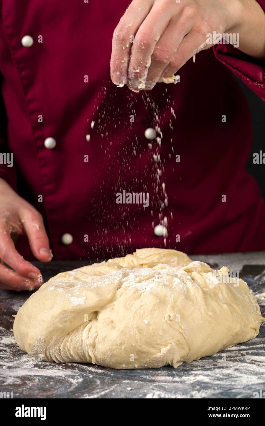 Professioneller Koch macht Hefeteig. Der Küchenchef bereitet Hefeteig für Pizza, Brot und Nudeln zu Stockfoto