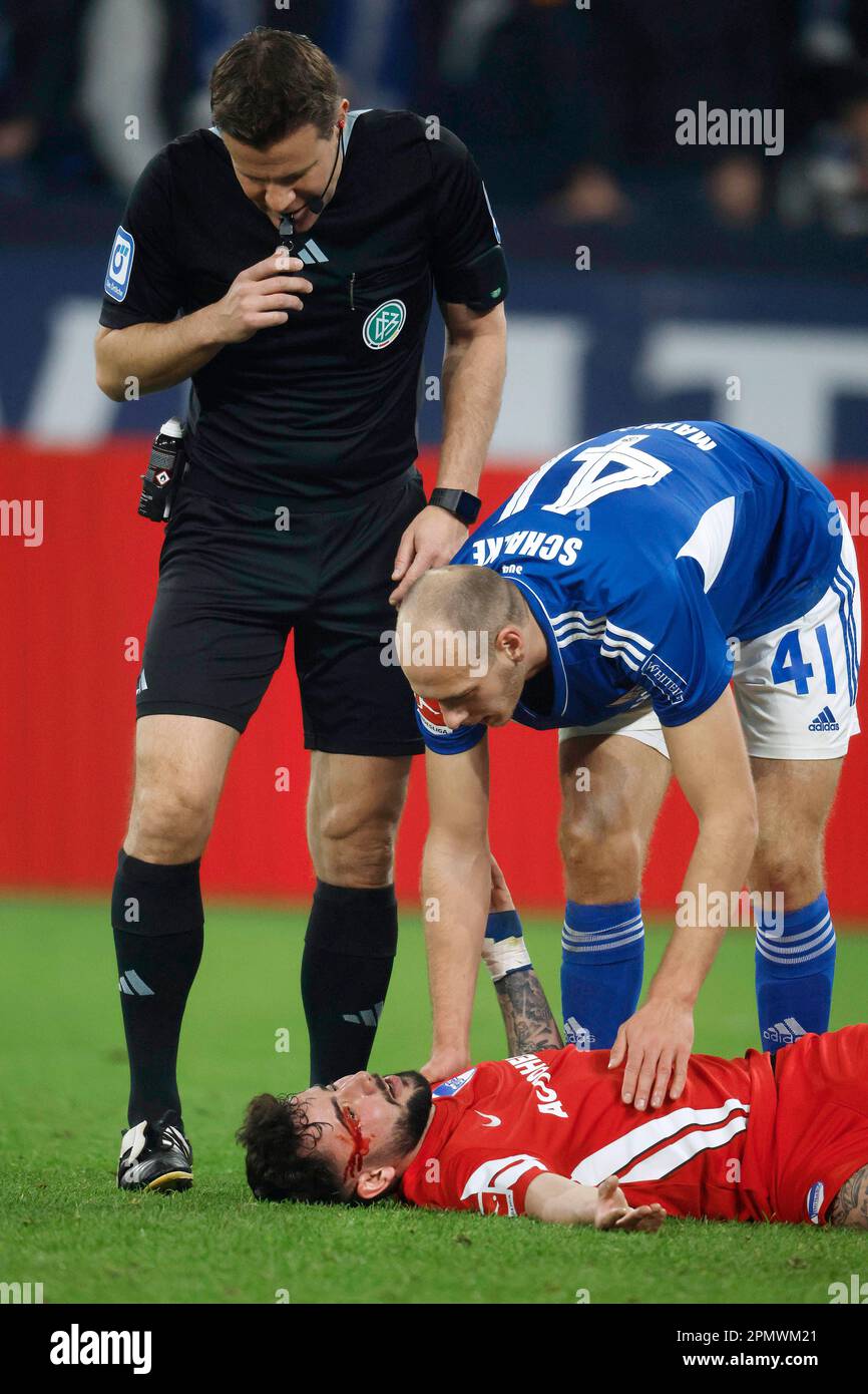 Gelsenkirchen, Deutschland, 1. Fussball Bundesliga 28. Spieltag FC Schalke 04 vs.Hertha BSC Berlin 5:2 am 14. 04. 2023 in der Veltins Arena auf Schalke in Gelsenkirchen SR. Felix BRYCH -L- und Henning MATRICIANI (S04) -R- kümmern sich um den am Boden liegenden und verletzten Marco RICHTER (HBSC) Foto: Norbert Schmidt, Düsseldorf Stockfoto