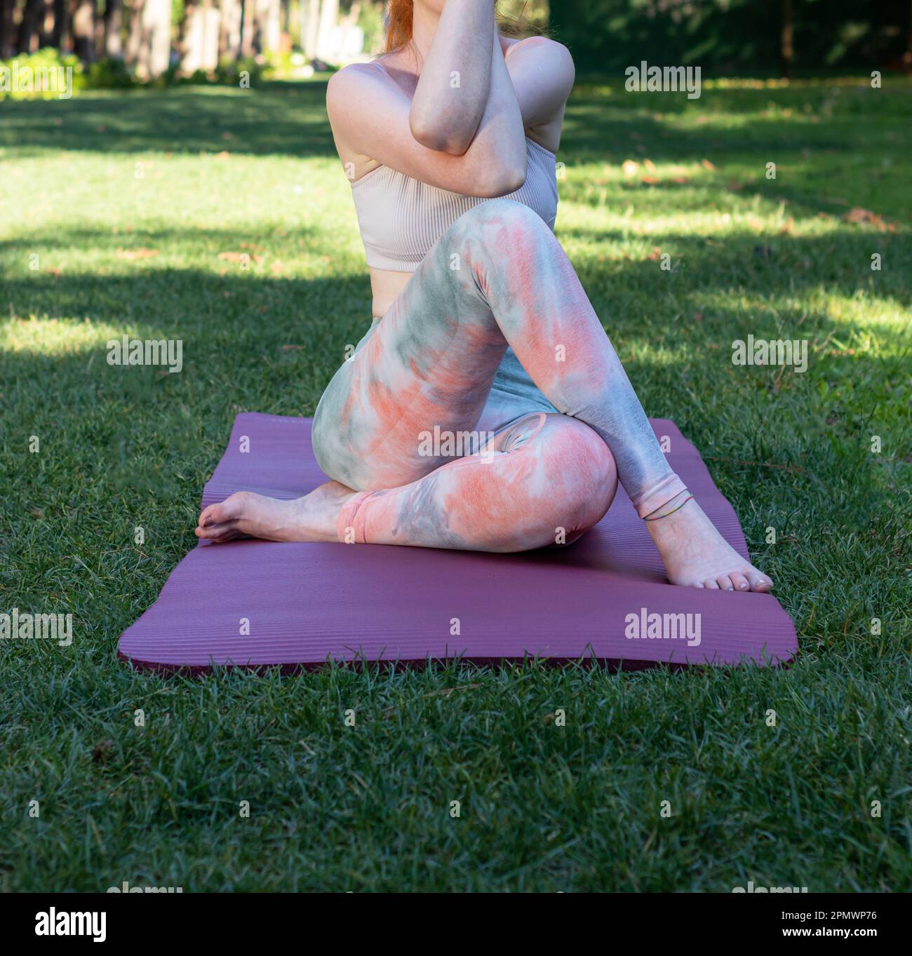 Eine rothaarige, hellhäutige Frau, die Yoga und Meditation im Wald praktiziert Stockfoto