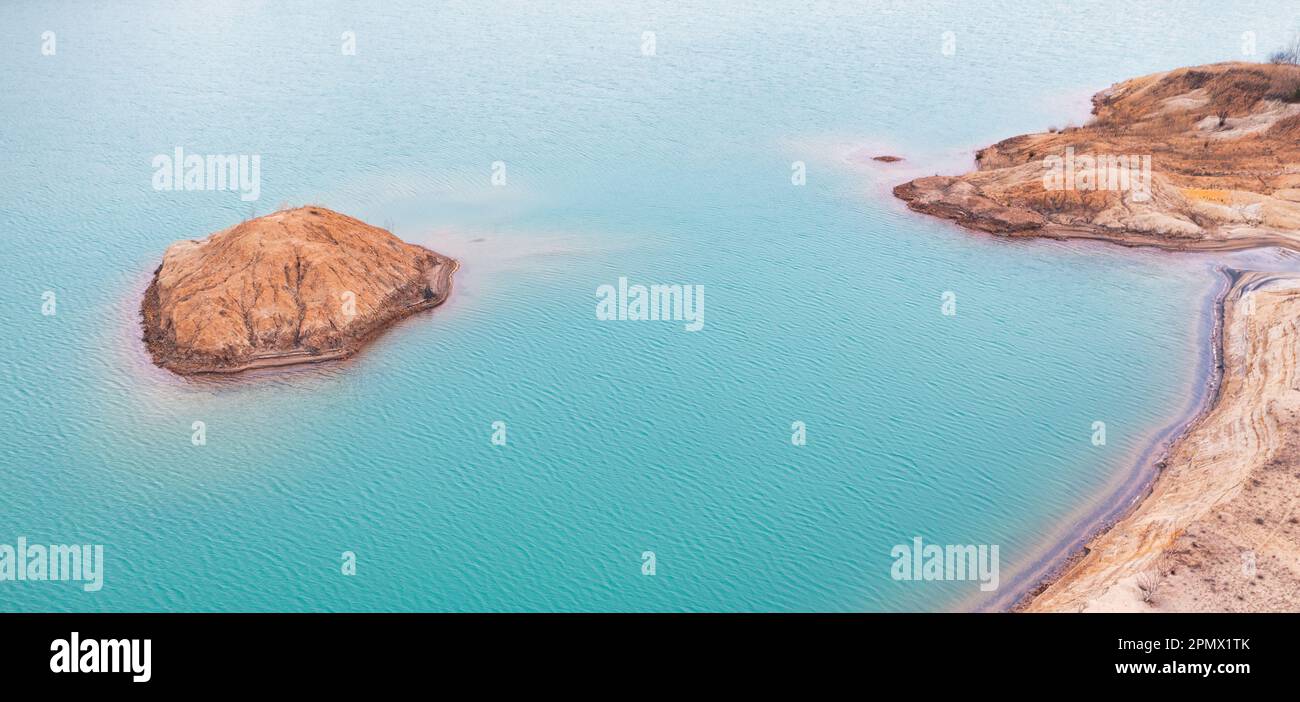 Dieses fesselnde Drohnenbild bietet eine einzigartige Perspektive auf eine Titanmine und unterstreicht die lebendigen Farben der Flüssigkeitsreservoirs Stockfoto