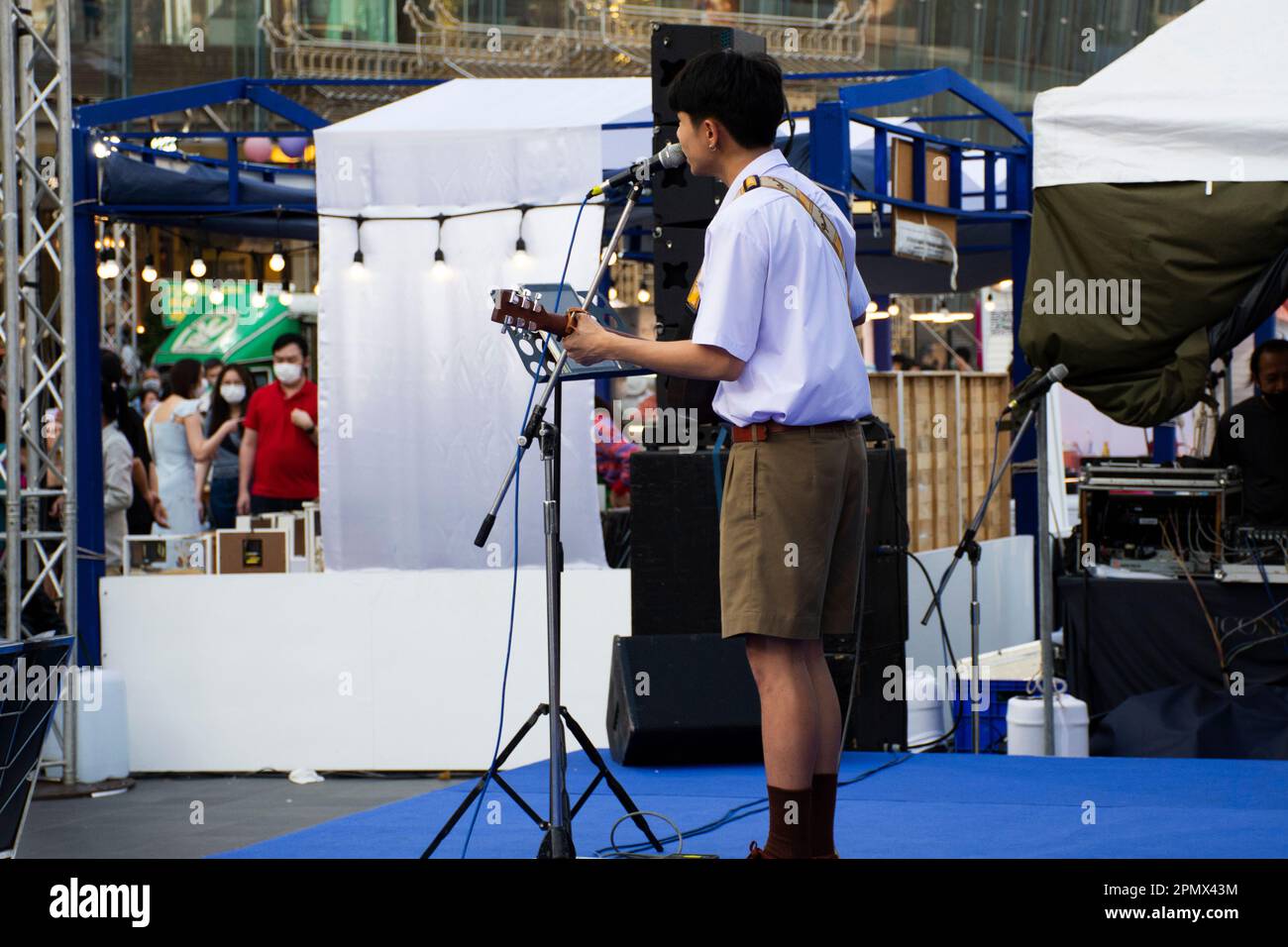 Thailändischer Studentenmusiker spielt klassisches Gitarreninstrument auf der Bühne bei einer Festivalveranstaltung für Showreisende auf der Terrasse im Iconsiam Departm Stockfoto
