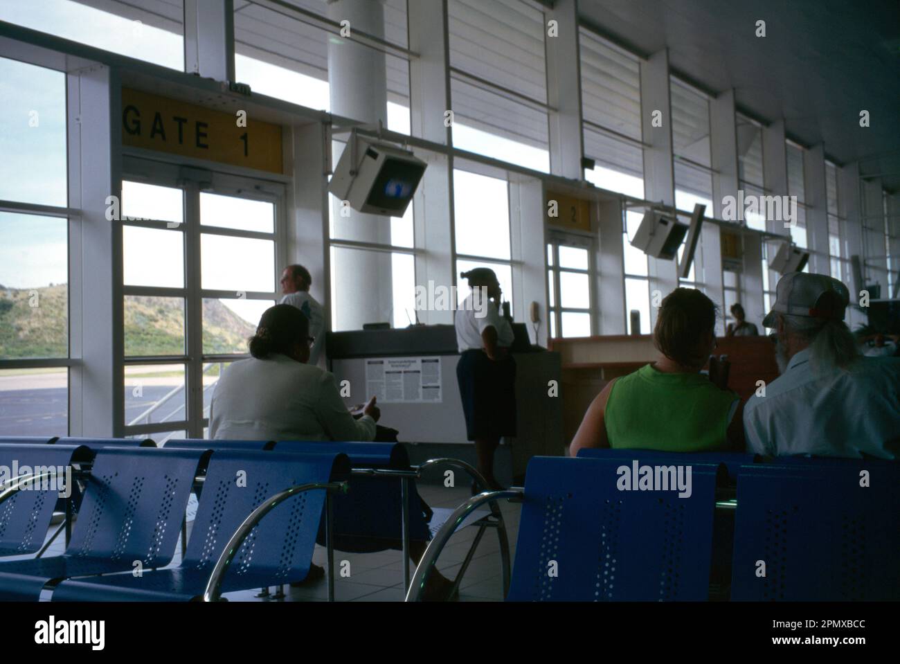 Passagiere des Flughafens St. Kitts Bradshaw warten am Terminal by Gates Stockfoto