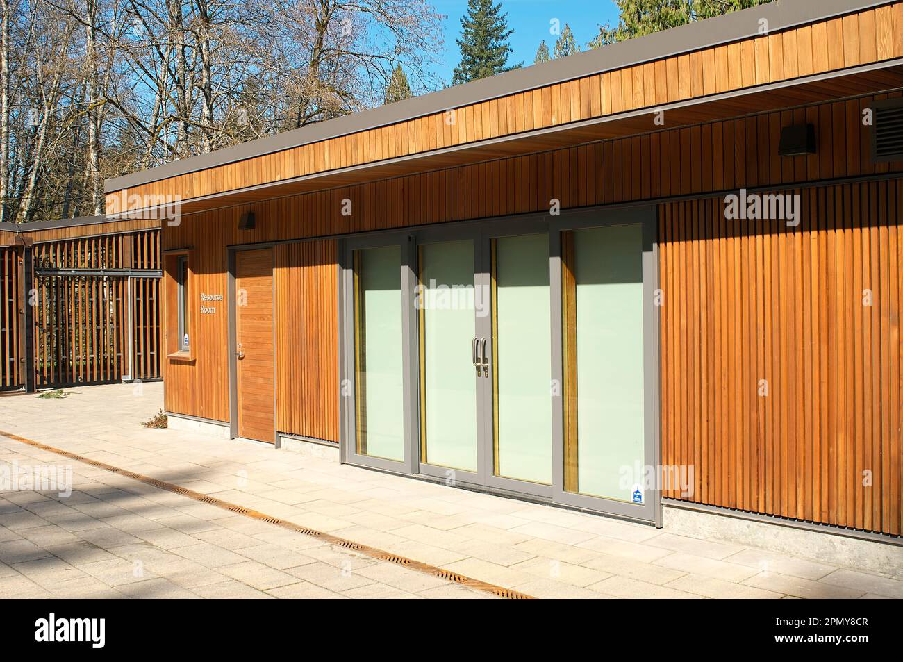 Ein flaches Gebäude mit vertikaler Zedernverkleidung und Doppelglastüren in der Fischzuchtanlage Bell-Irving. - Maple Ridge, B.C., Kanada. Stockfoto