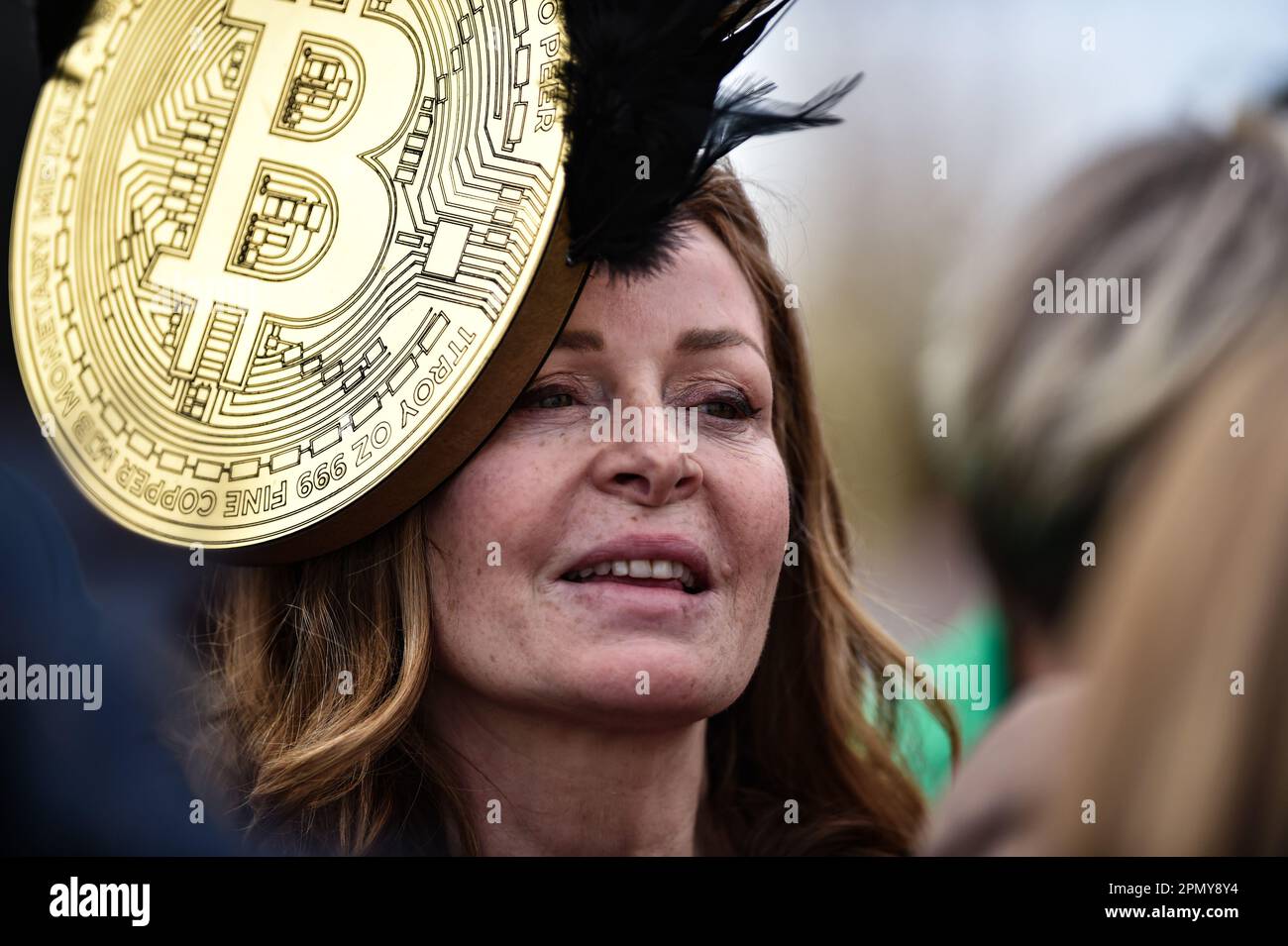 15. April 2023; Aintree Racecourse, Aintree, Merseyside, England: 2023 Grand National Festival Day 3; Rennfans, die sich für diesen Anlass mit einem Bitcoin-Hut verkleidet haben Stockfoto