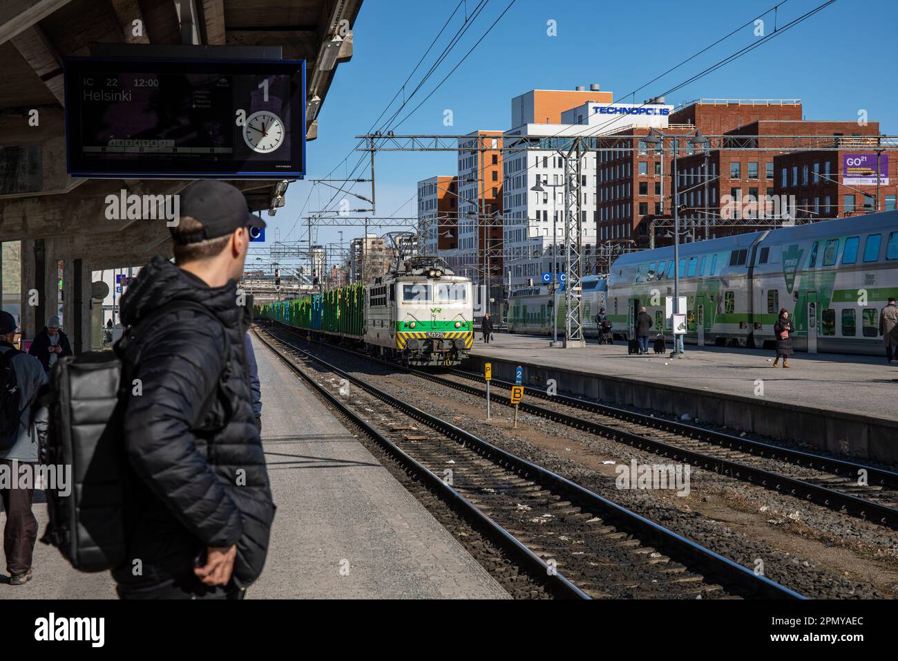 Ein Mann steht auf dem Bahnsteig und beobachtet, wie sich der Güterzug am Hauptbahnhof Tampere in Tampere, Finnland, nähert Stockfoto