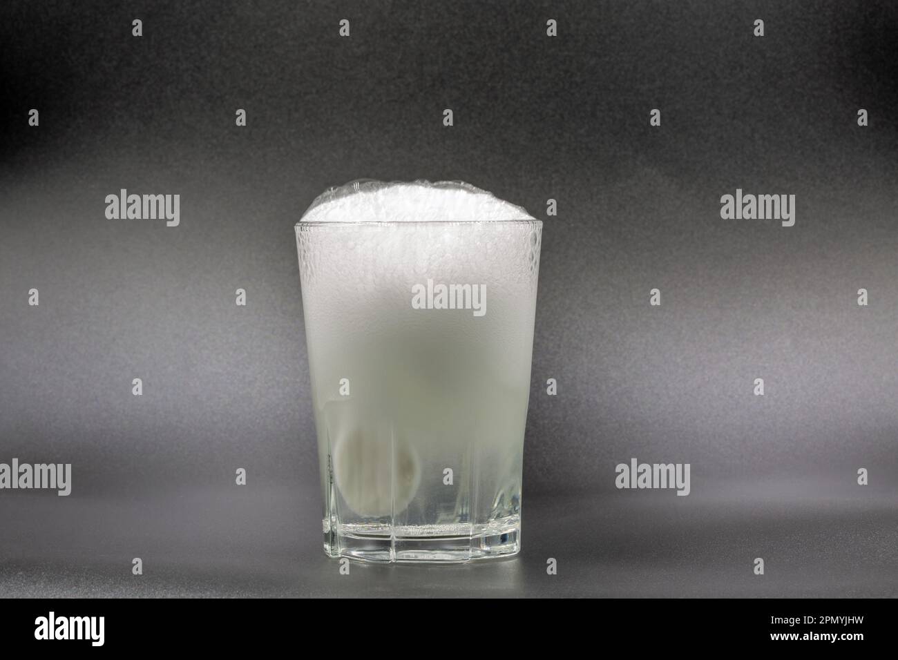 Auflösen von Brausetabletten in einem Glas mit Wassernaht auf Schwarz Stockfoto