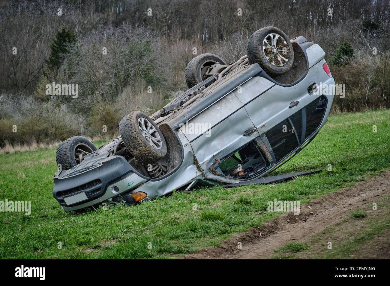 Großer SUV nach einem Überschlag auf dem Dach in der Natur. Autounfall auf dem landwirtschaftlichen Feld. Unfall auf staubigen Landstraßen. Isoliert, deformiert, abgestürzt Stockfoto