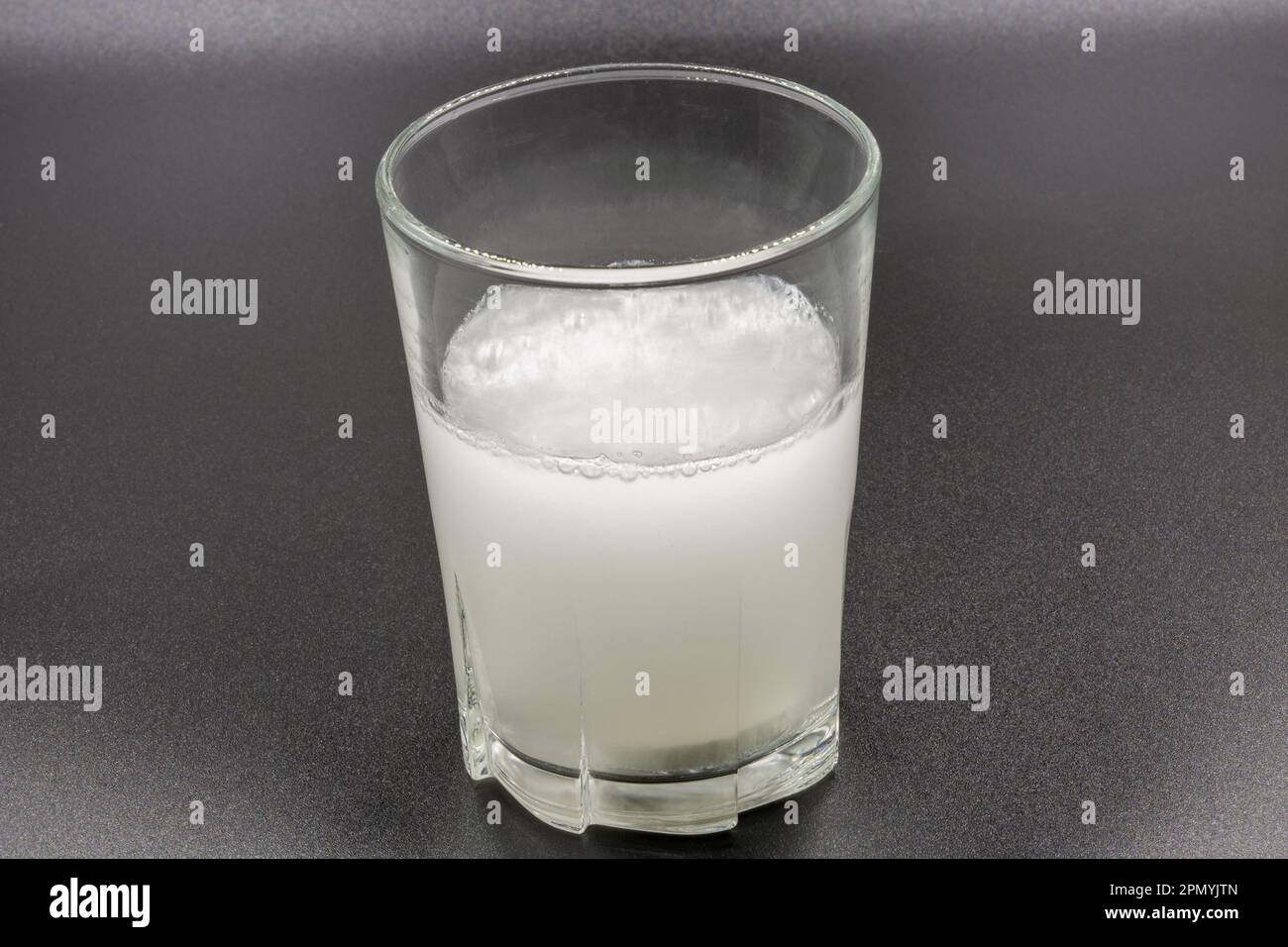 Auflösen von Brausetabletten in einem Glas mit Wassernaht auf Schwarz Stockfoto