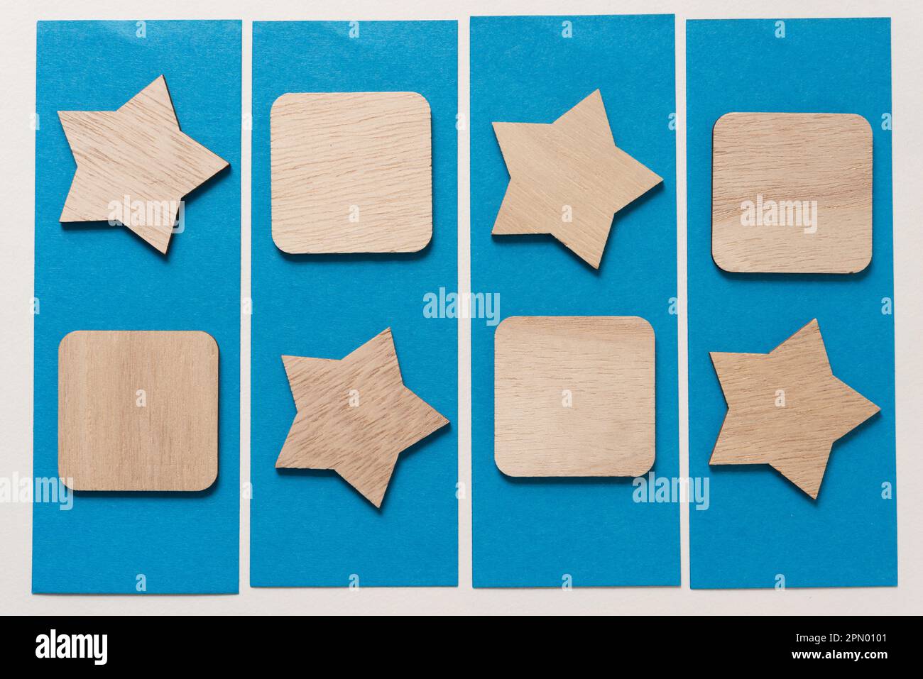 Sternform aus Holz und quadratische Form auf blauen Papierstreifen mit Rand Stockfoto