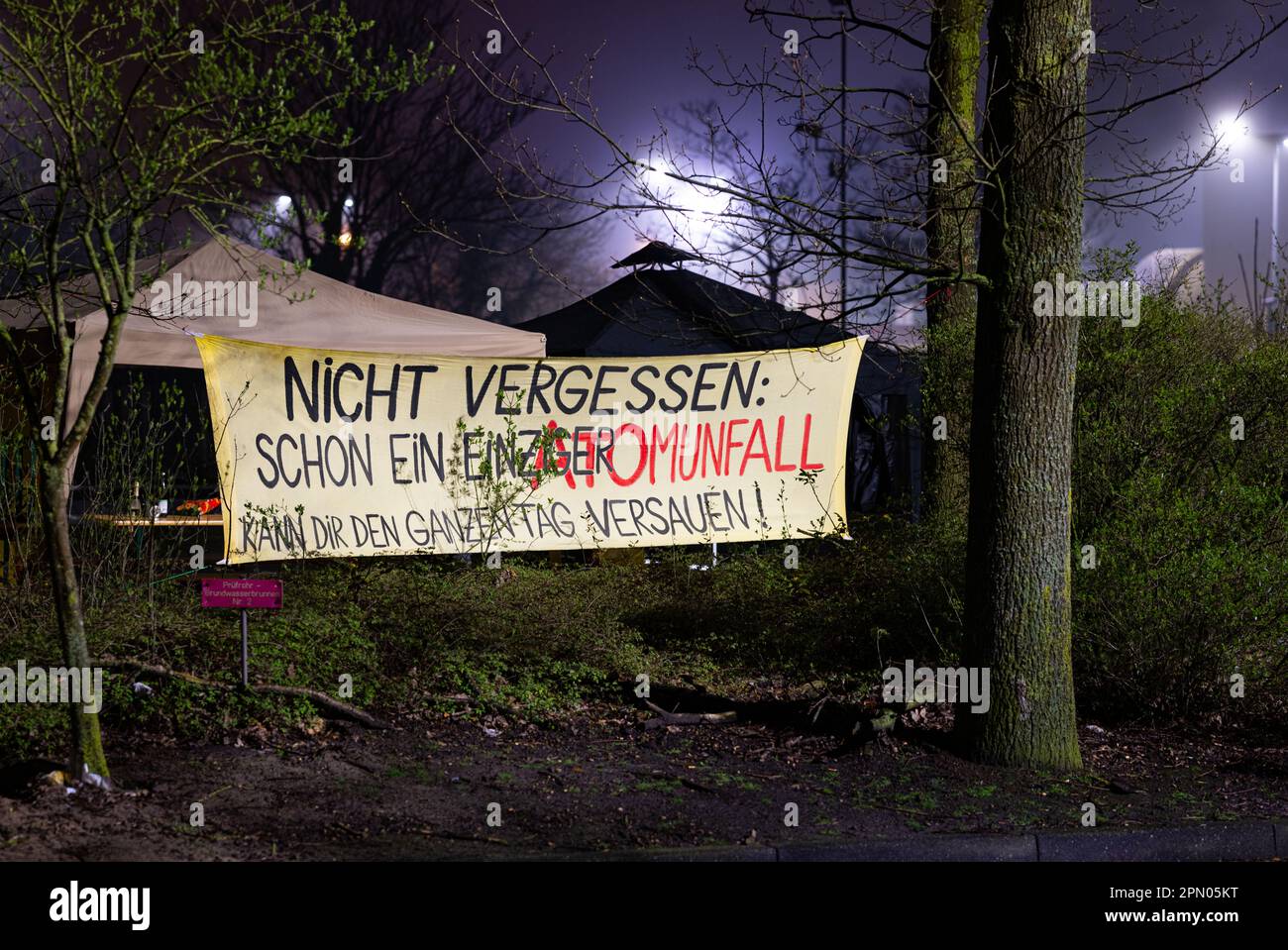 Lingen, Deutschland. 15. April 2023. Vor dem Standort des Kernkraftwerks Emsland hängt ein Banner mit der Aufschrift "nicht vergessen - selbst ein einziger nuklearer Unfall kann den ganzen Tag ruinieren!". Die Trennung der Kernkraftwerke Isar 2, Neckarwestheim und Emsland vom Stromnetz am Samstag markierte das Ende der Ära der kommerziellen Stromerzeugung mit Kernkraftwerken in Deutschland. Kredit: Guido Kirchner/dpa/Alamy Live News Stockfoto Lingen, Deutschland. 15. April 2023. Vor dem Standort des Kernkraftwerks Emsland hängt ein Banner mit der Aufschrift "nicht vergessen - selbst ein einziger nuklearer Unfall kann den ganzen Tag ruinieren!". Die Trennung der Kernkraftwerke Isar 2, Neckarwestheim und Emsland vom Stromnetz am Samstag markierte das Ende der Ära der kommerziellen Stromerzeugung mit Kernkraftwerken in Deutschland. Kredit: Guido Kirchner/dpa/Alamy Live News Stockfoto