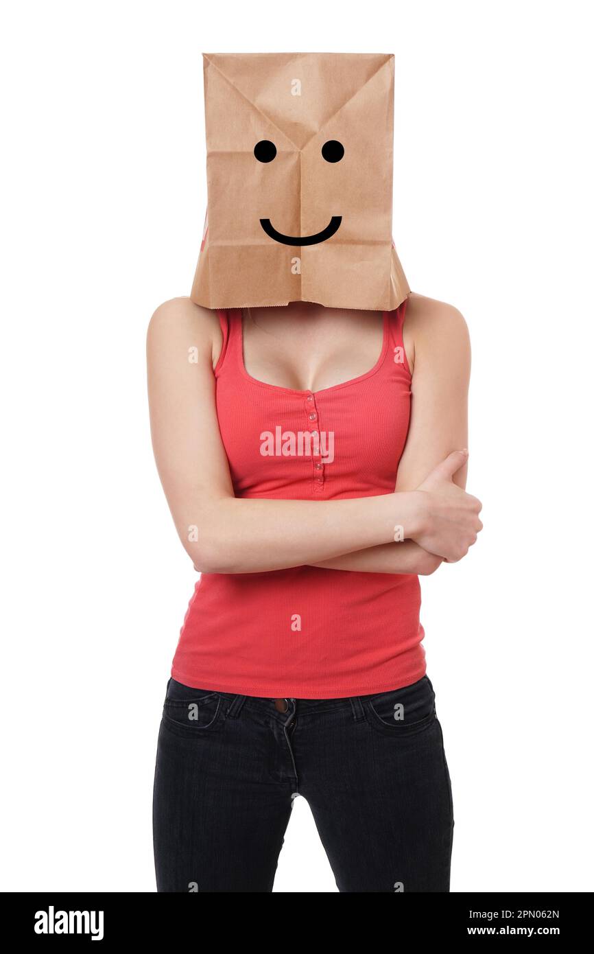 Junge Frau mit Papiertüte mit Smiley über ihrem Kopf Stockfoto