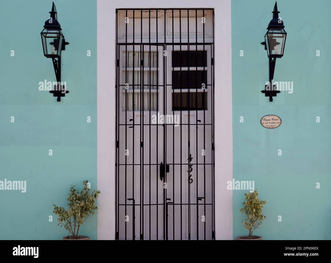 Ein grünes Gebäude mit einer Tür und Wandbehängen in Merida, Yucatan, Mexiko. Stockfoto