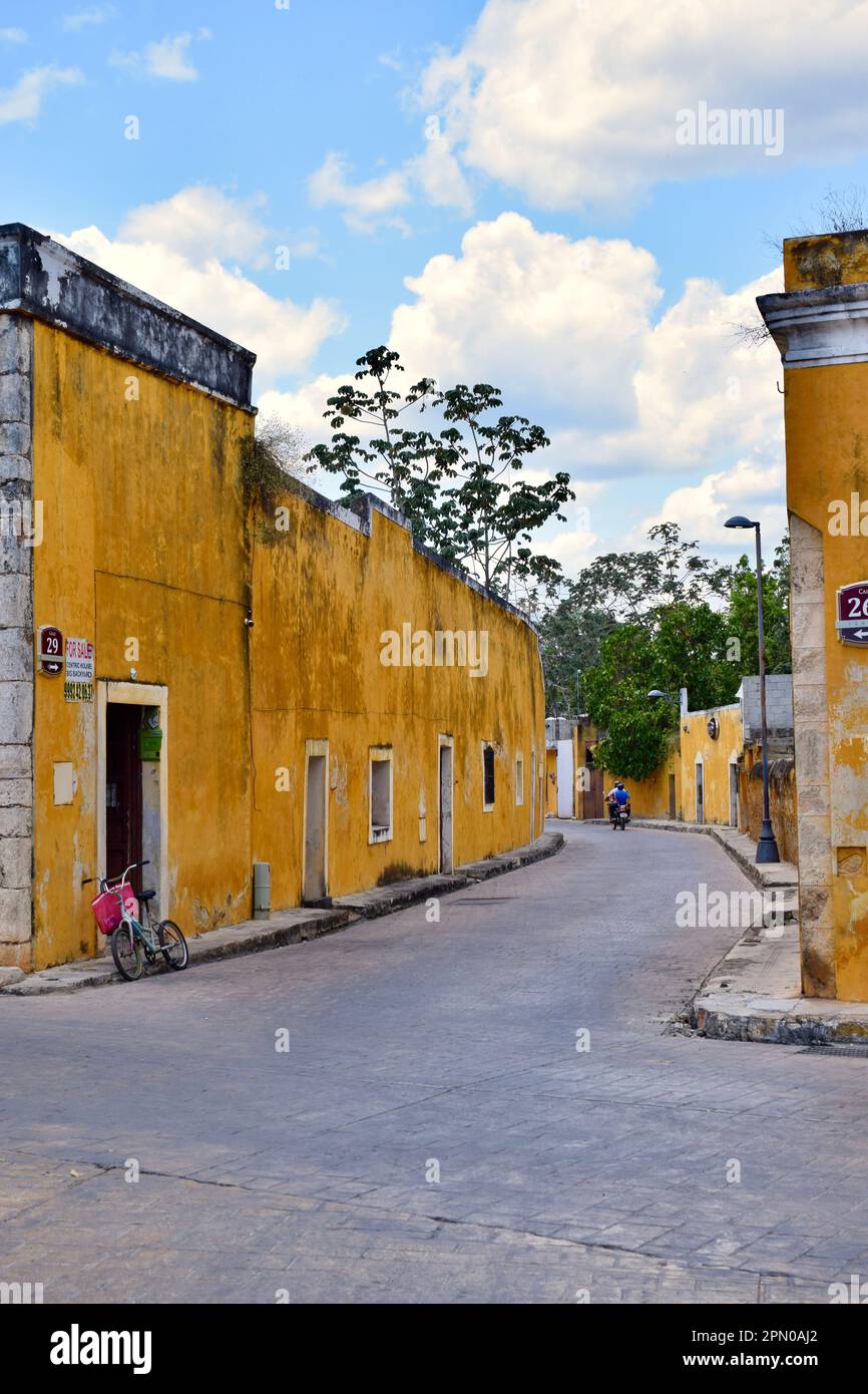 Ein vertikales Bild einer bezaubernden Seitenstraße in der gelben Stadt Izamal, Yucatan, Mexiko. Stockfoto