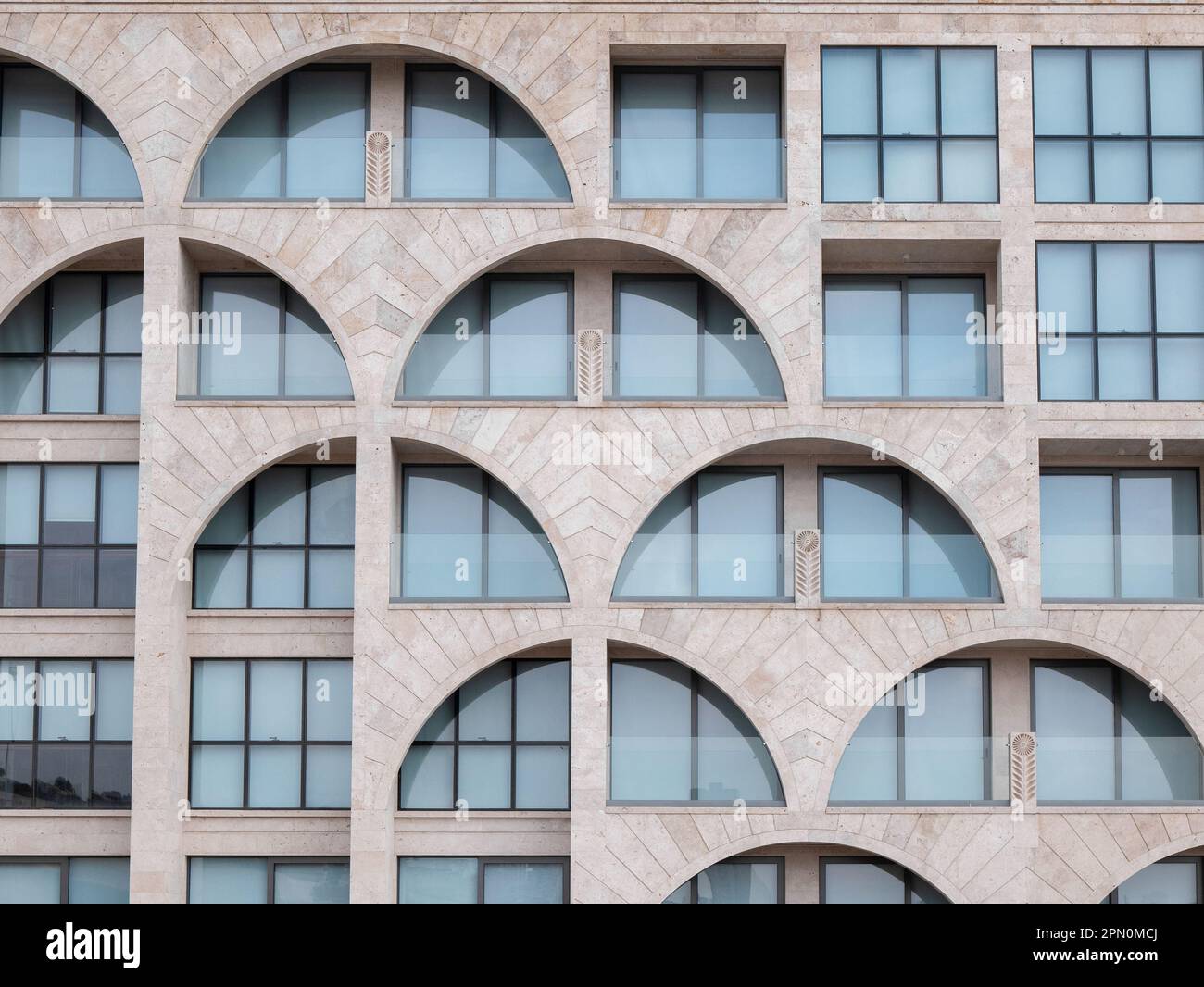 Eriwan, Armenien - 27. März 2023: Geometrische Fassade des modernen Tuffsteingebäudes mit halbrunden Fenstern Stockfoto