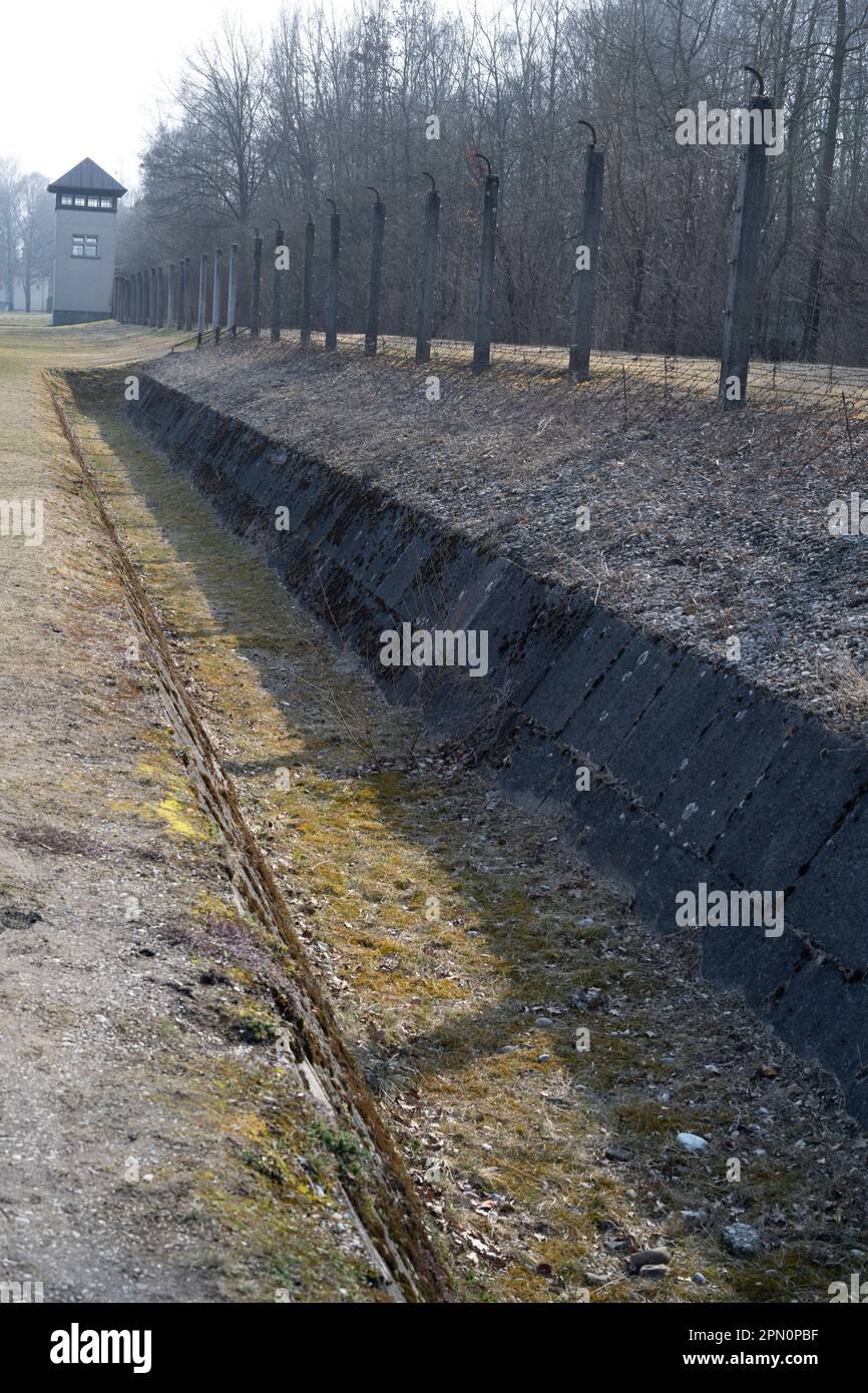 Graben und elektrischer Stacheldrahtzaun in der Nähe eines Wachturms, um Gefangene vor der Flucht zu bewahren Stockfoto