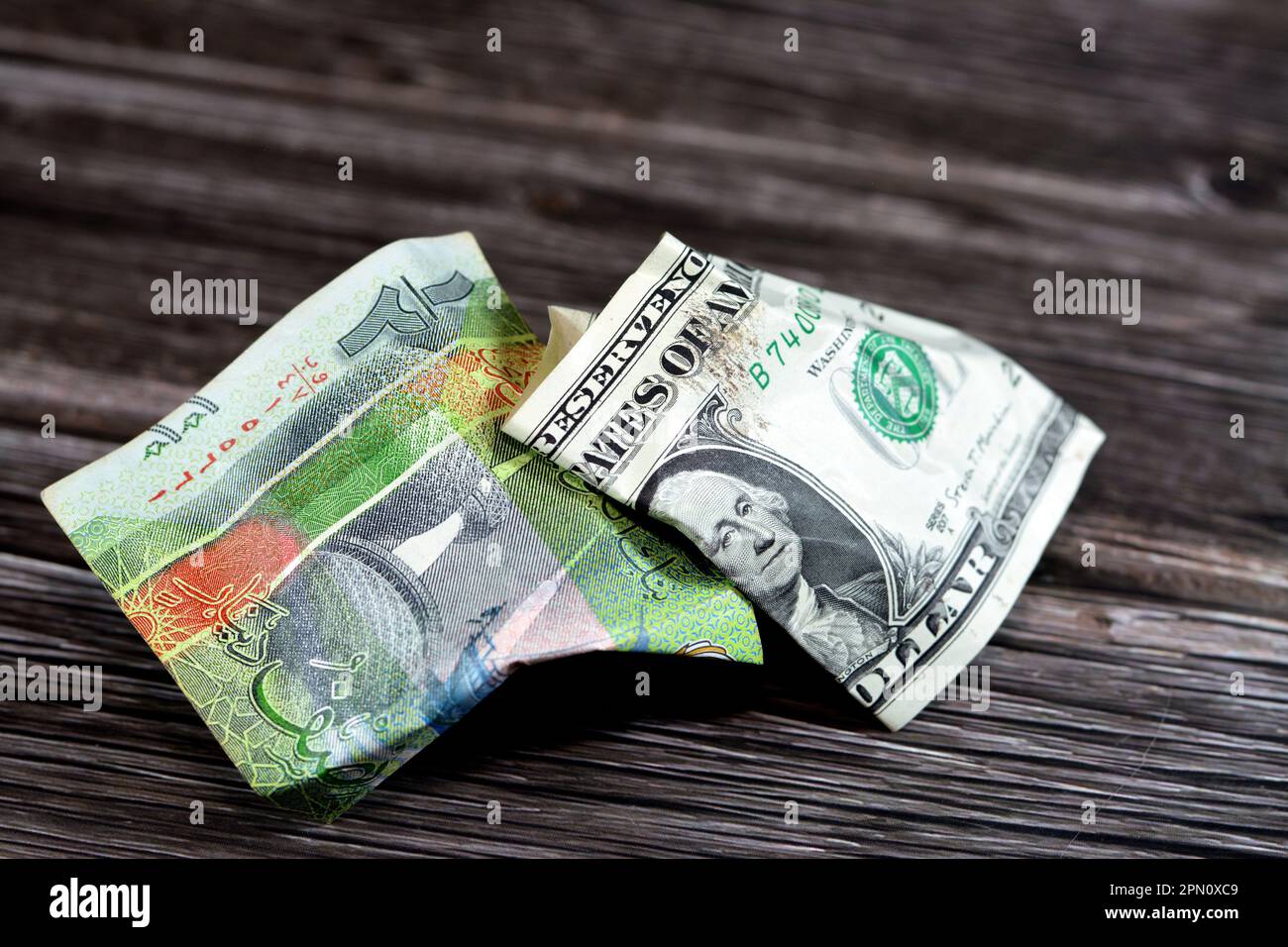 Zerknitterte und zerknitterte kuwaitische halbe KWD-Dinar-Banknote und 1 US-Dollar Bargeld, Geldinflation und Wertverlust, Drop Concept, Busin Stockfoto