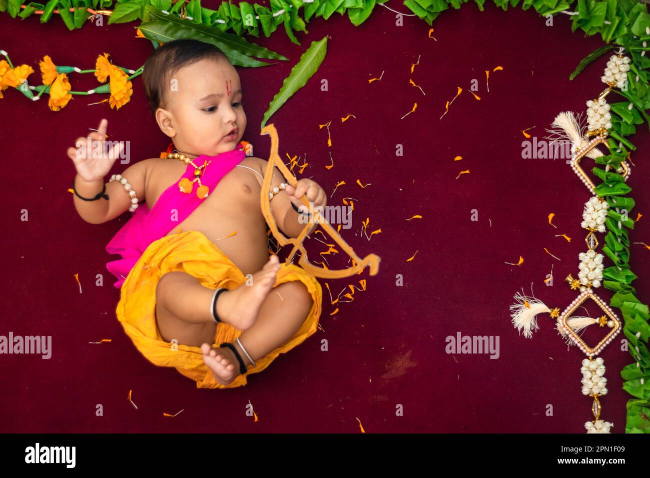 Süßer indischer Junge kleidet sich wie lord rama mit Schleife und Blumen aus dem oberen Winkel Stockfoto